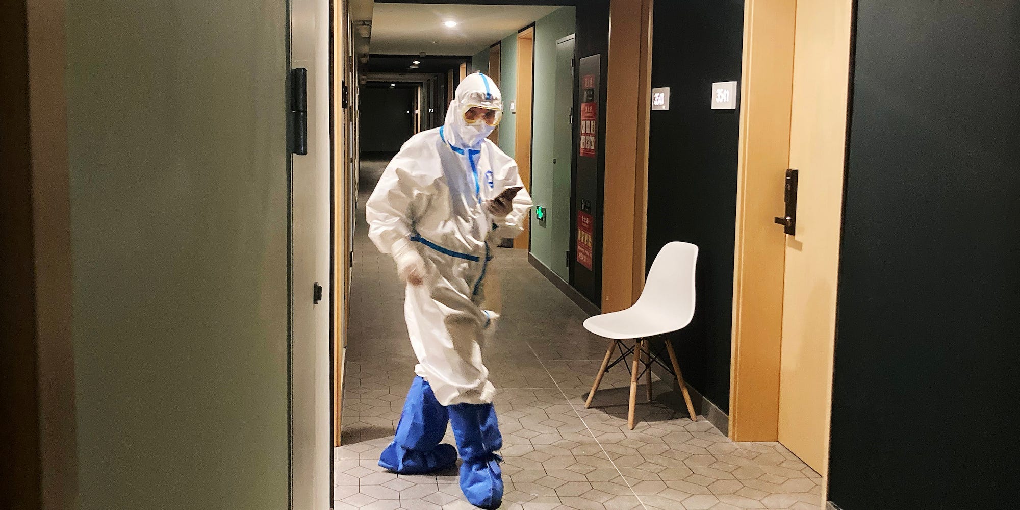 An employee in a hazmat suit walks through the COVID-19 isolation hotel hallway at the Beijing Olympics.