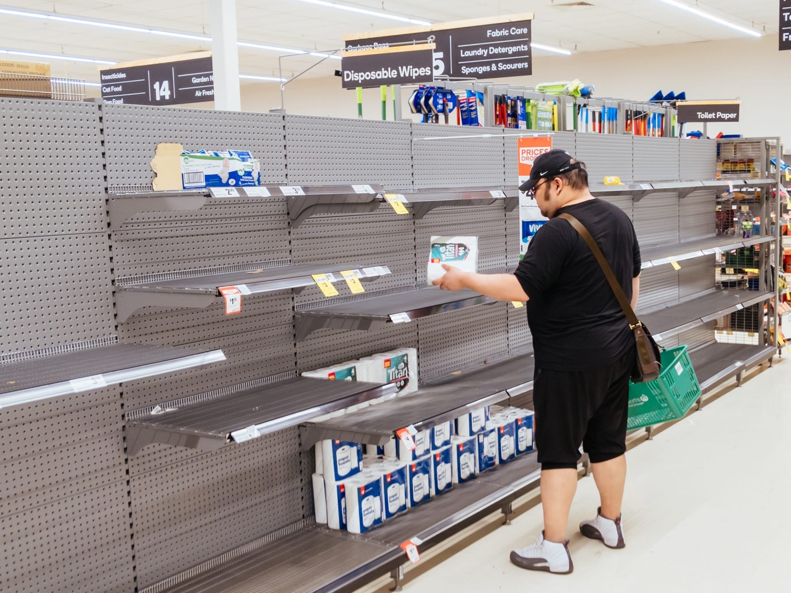 Empty supermarket shelves - A man looks for toilet paper in an Australian supermarket after panic buying due to the Coronavirus March 2020