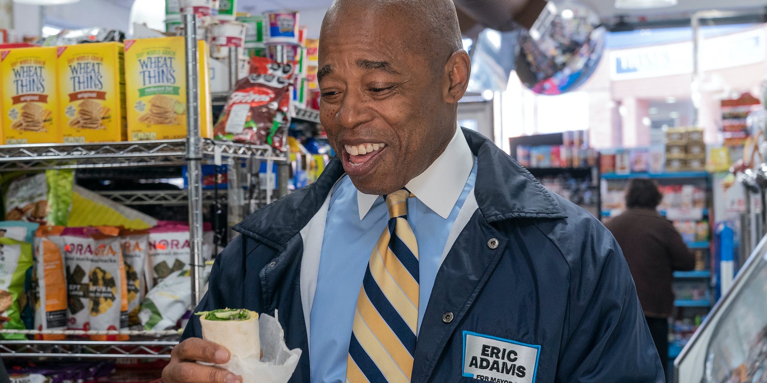 Eric Adams looks down at vegan wrap inside a New York City bodega.