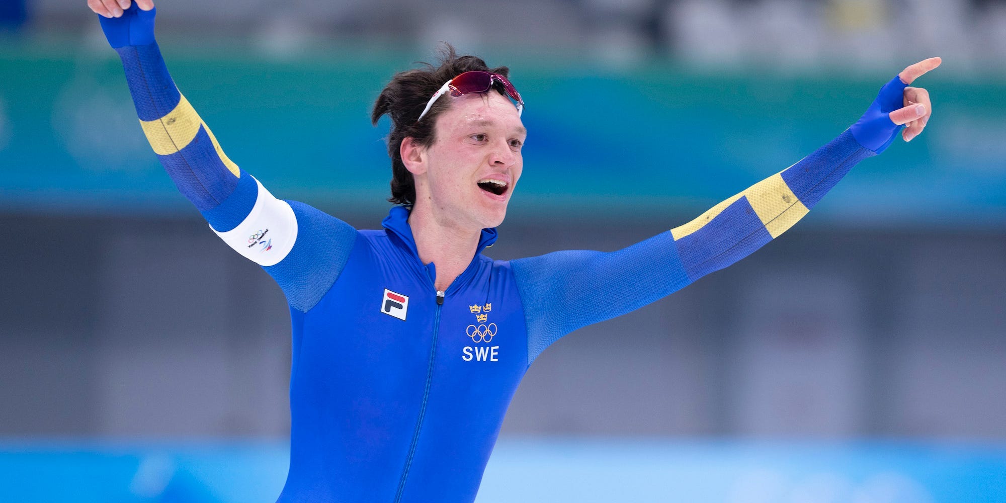 Nils van der Poel raises his hands in celebration at the 2022 Olympics.