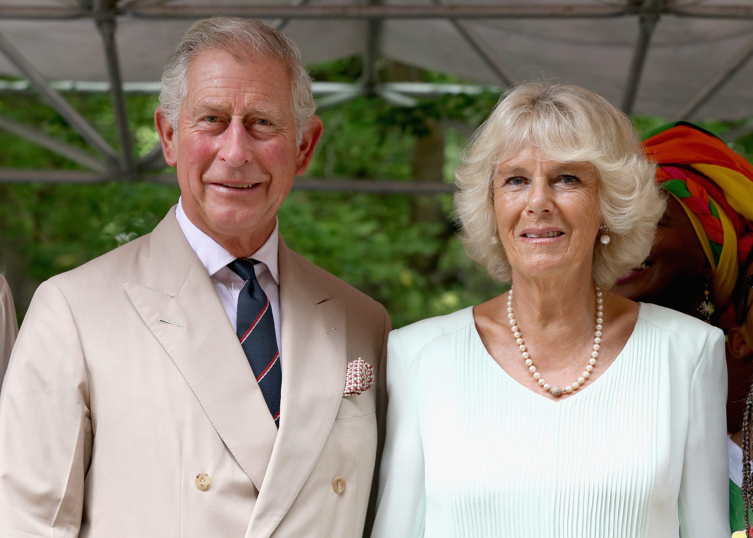 Princes Charles and Camilla, Duchess of Cornwall, standing next to each other and smiling at the camera,