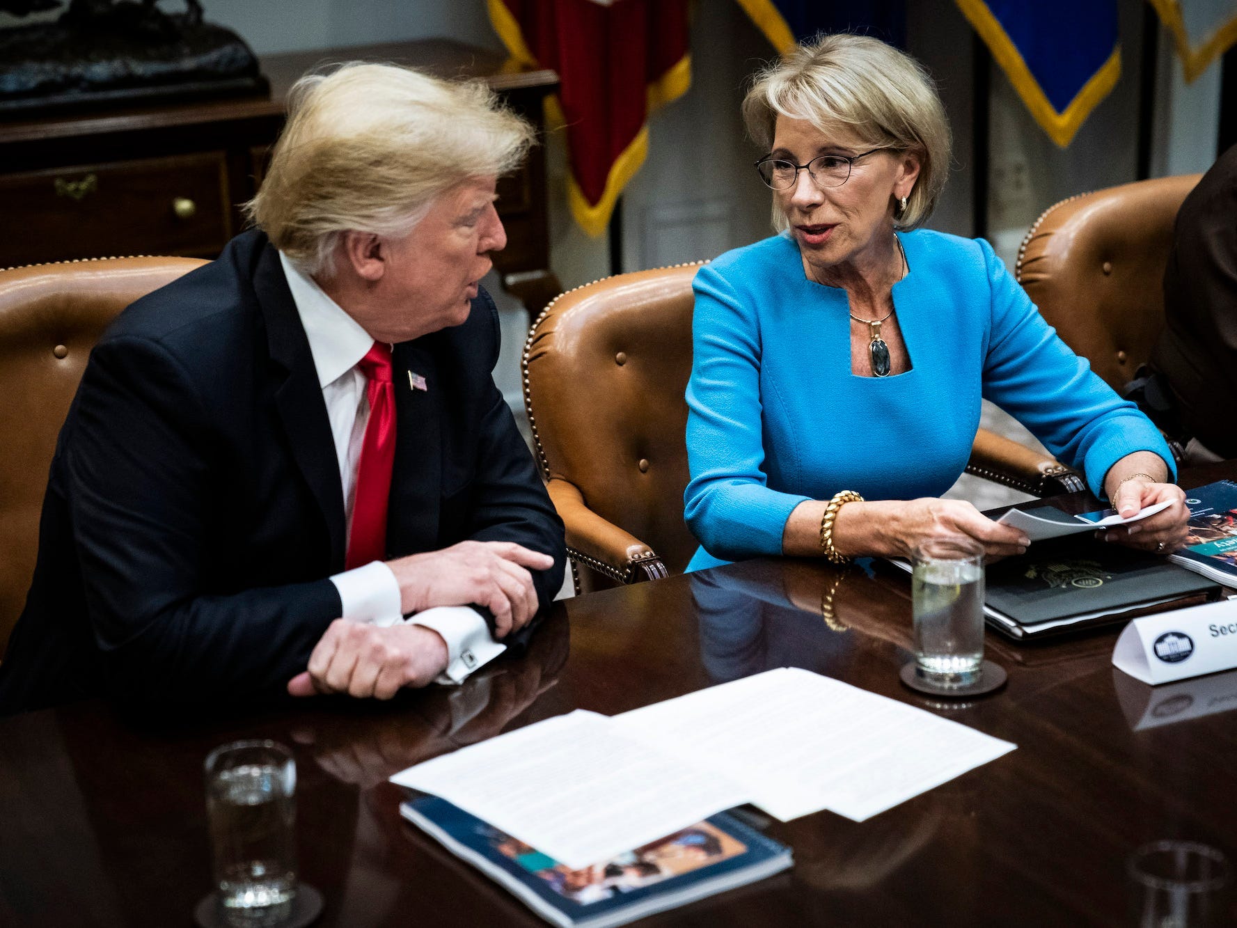 WASHINGTON, DC - DECEMBER 18 : President Donald J. Trump speaks with Secretary of Education Betsy DeVos at a roundtable with family members of victims, state and local officials, and Cabinet members to discuss recommendations in the Federal Commission on School Safety Report in the Roosevelt Room at White House on Tuesday, Dec. 18, 2018 in Washington, DC. (Photo by Jabin Botsford/The Washington Post via Getty Images)