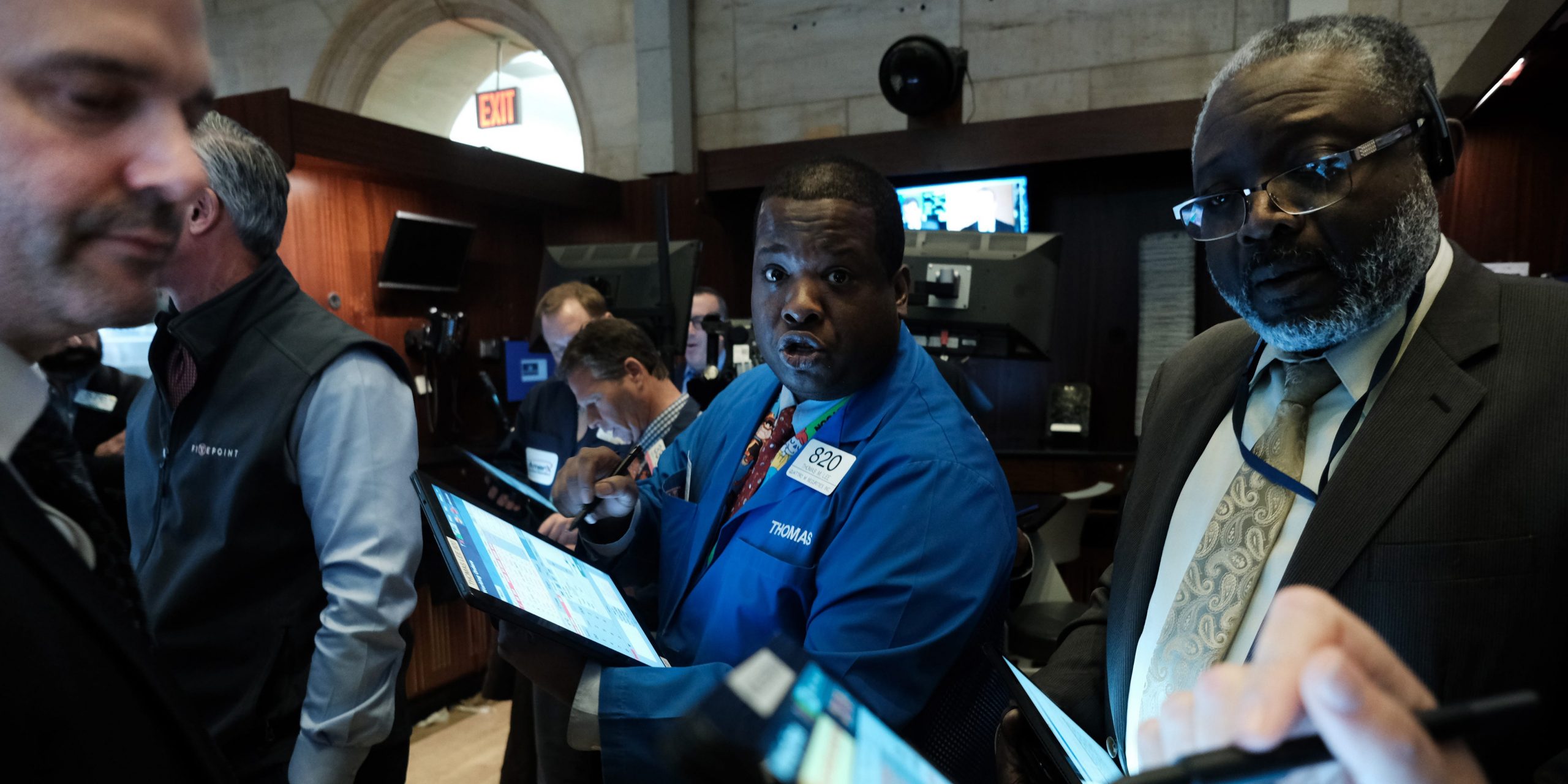 Three traders work on the floor of the New York Stock Exchange