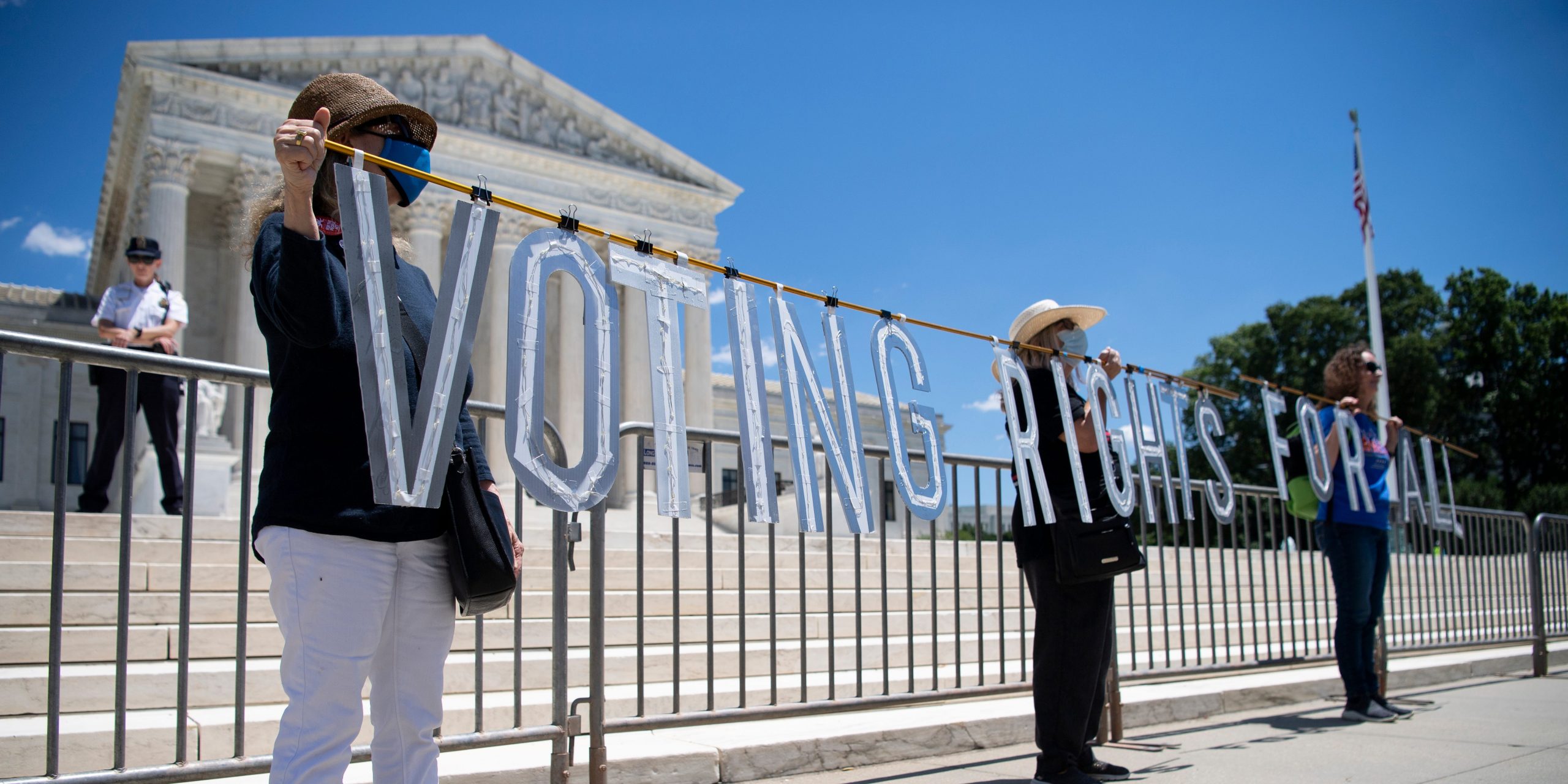 Voting rights protestors demonstrate in front of the Supreme Court