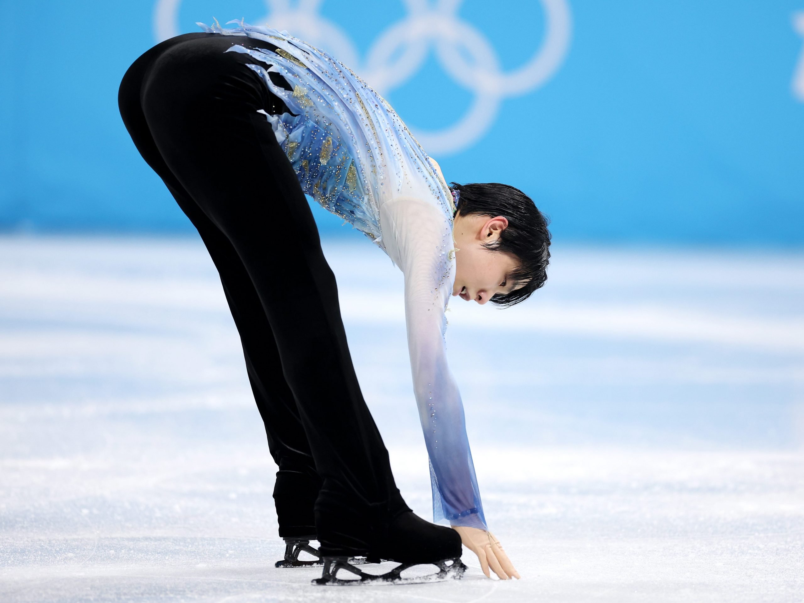 In image of Yuzuru Hanyu touching the ice during the men's singles skating short program