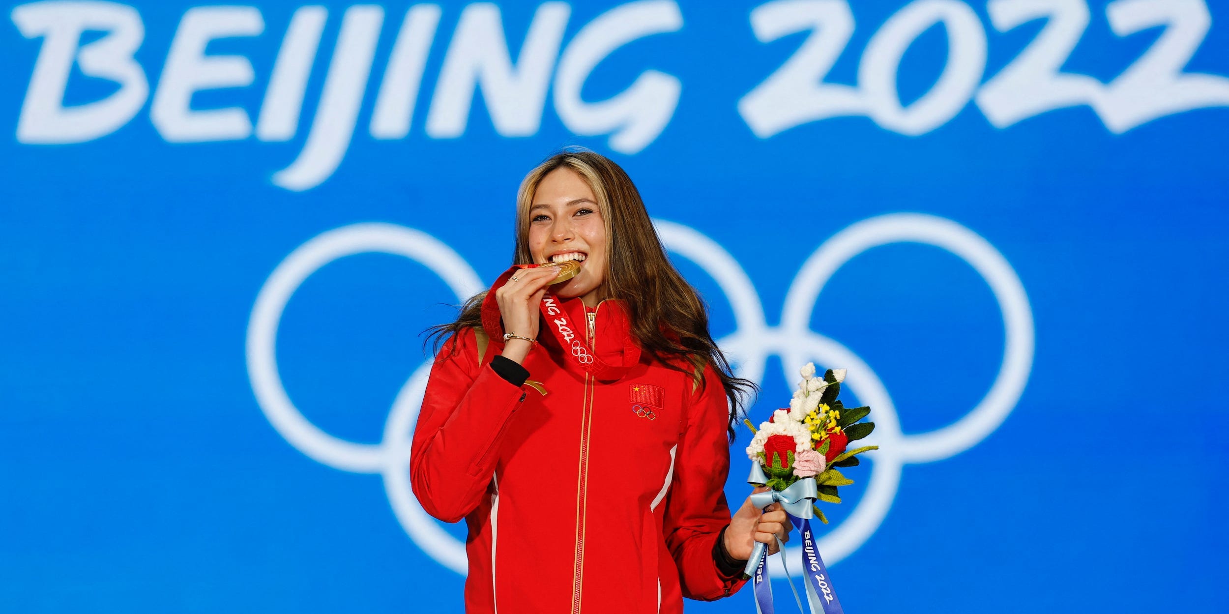 Eileen Gu poses with her gold medal from the women's freestyle skiing big air event at the 2022 Beijing Olympics.