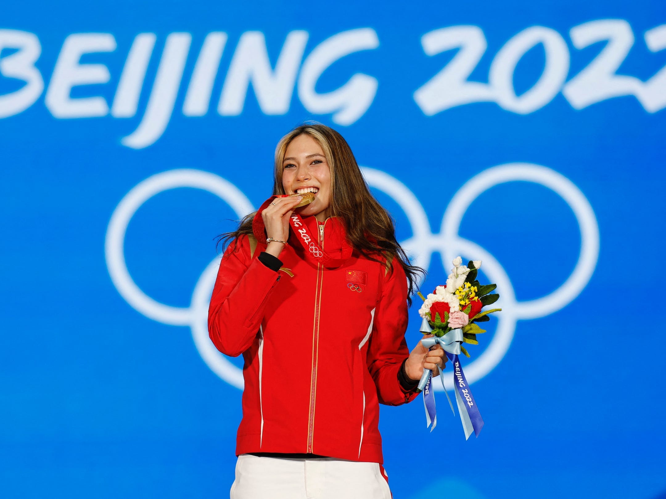 Eileen Gu poses with her gold medal from the women's freestyle skiing big air event at the 2022 Beijing Olympics.