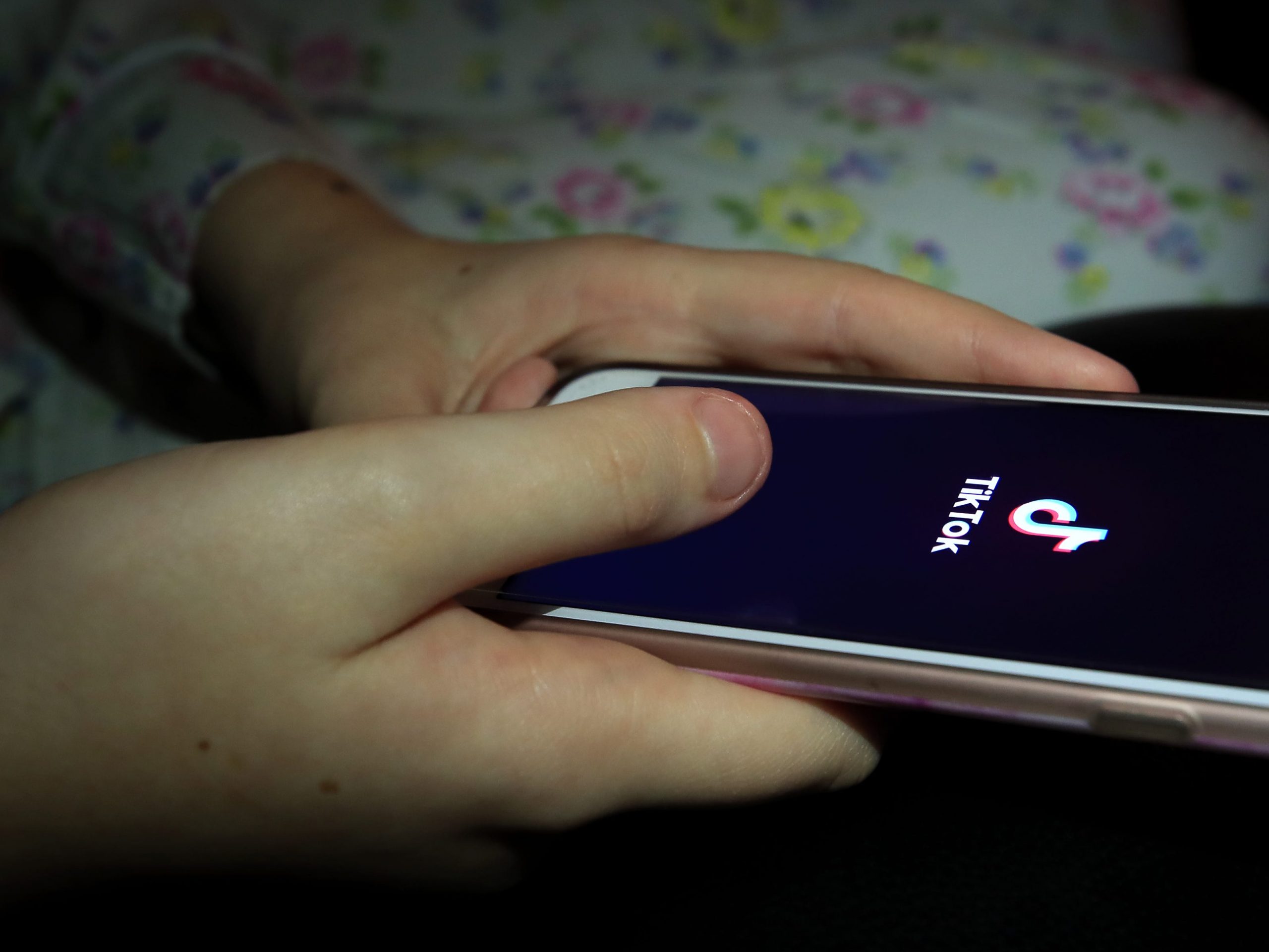 A young girl uses the TikTok app on a smartphone.