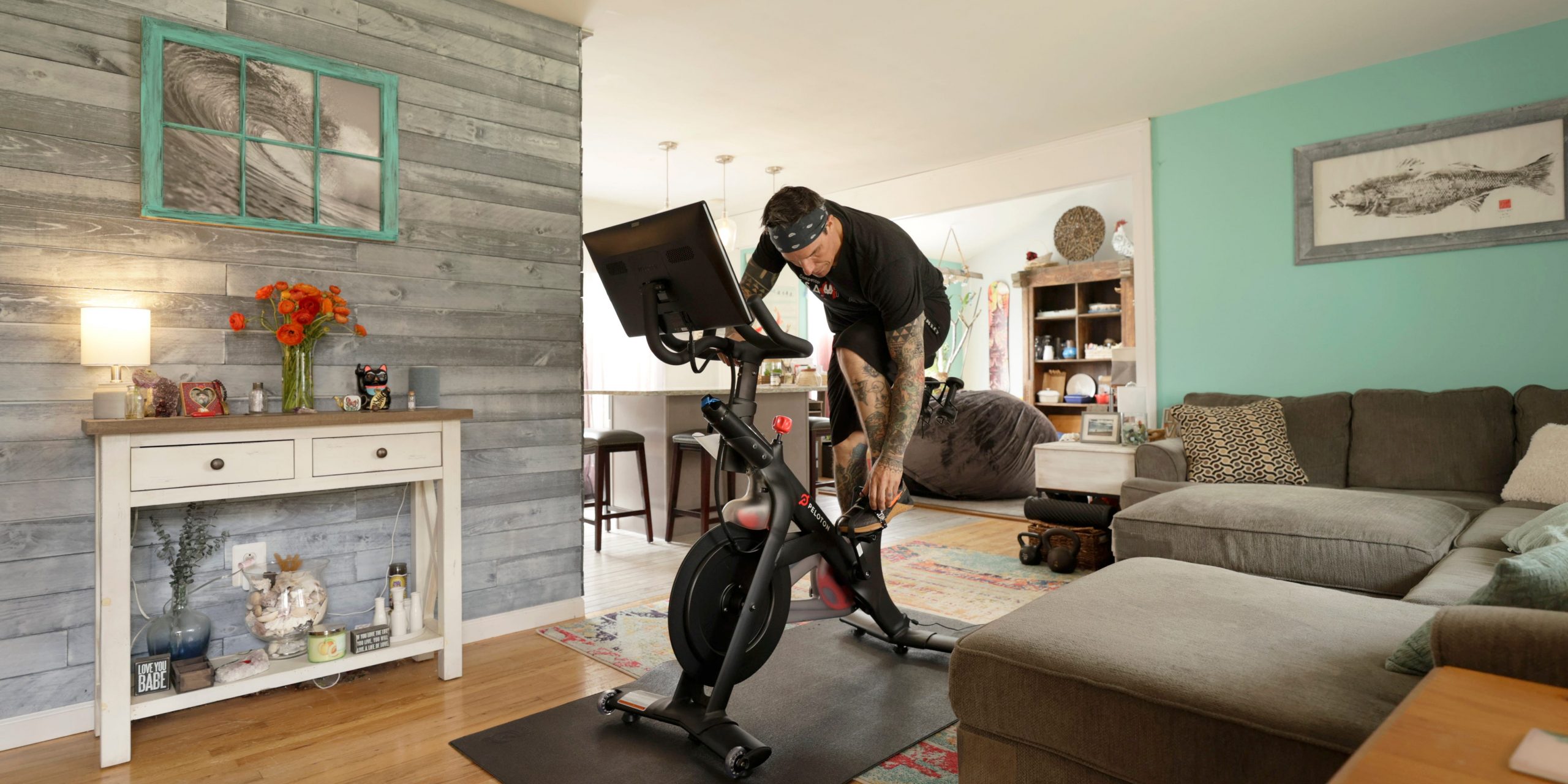 A man riding a Peloton bike in his living room.