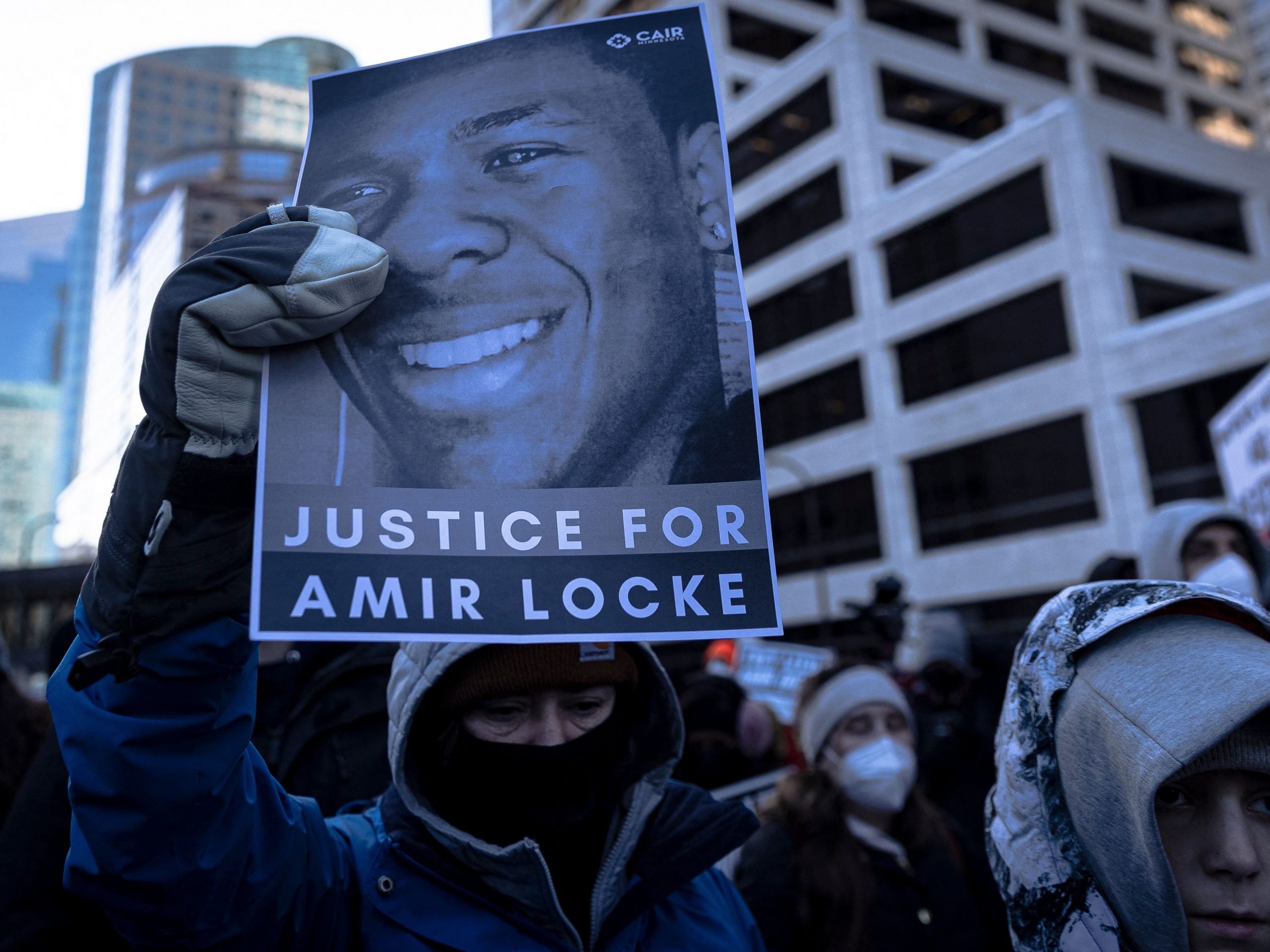 A demonstrator holds a photo of Amir Locke during a rally in protest of his killing, outside the Hennepin County Government Center in Minneapolis, Minnesota on February 5, 2022.