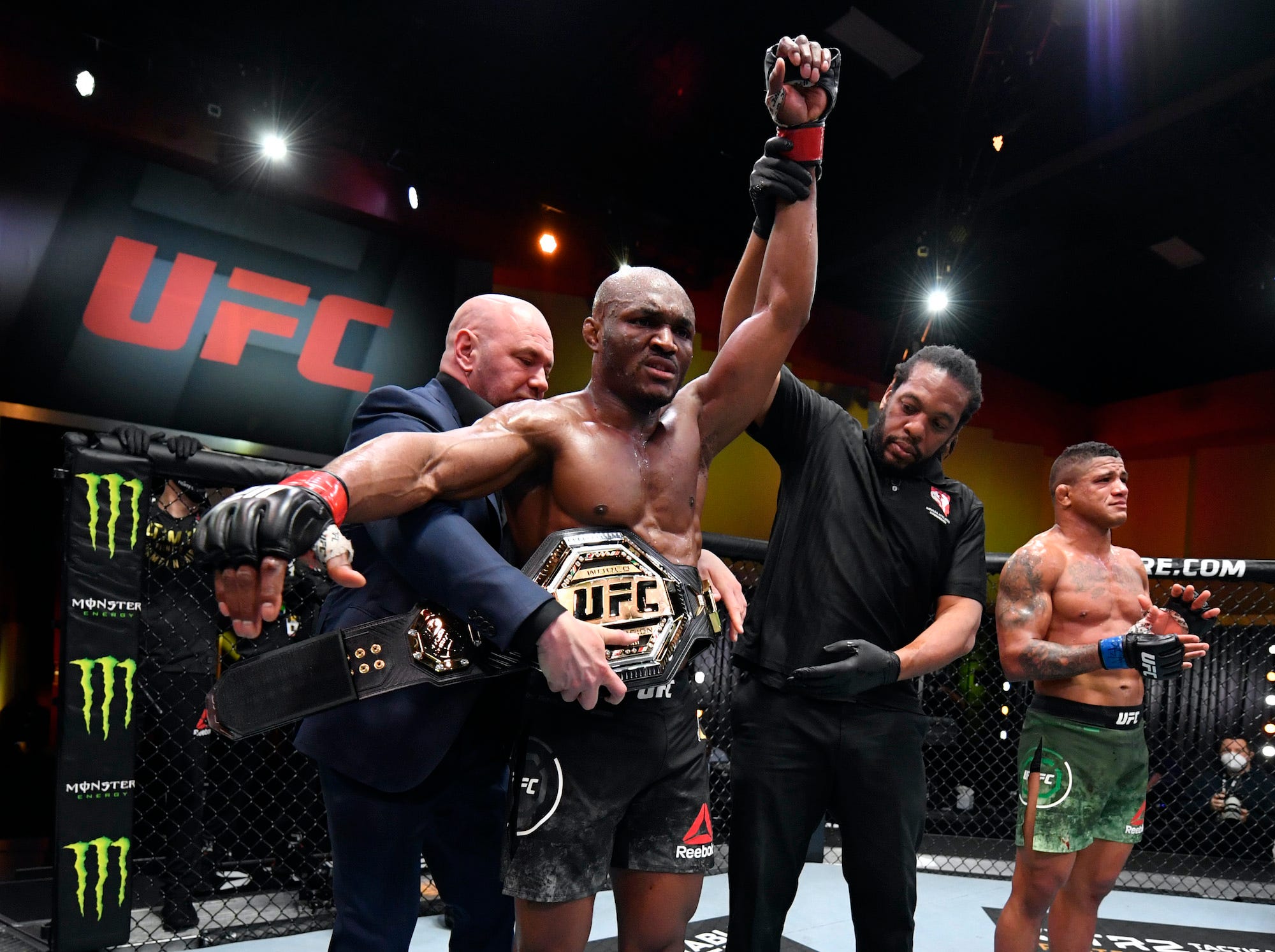 Dana White wraps the UFC championship belt around Kamaru Usman's waist.