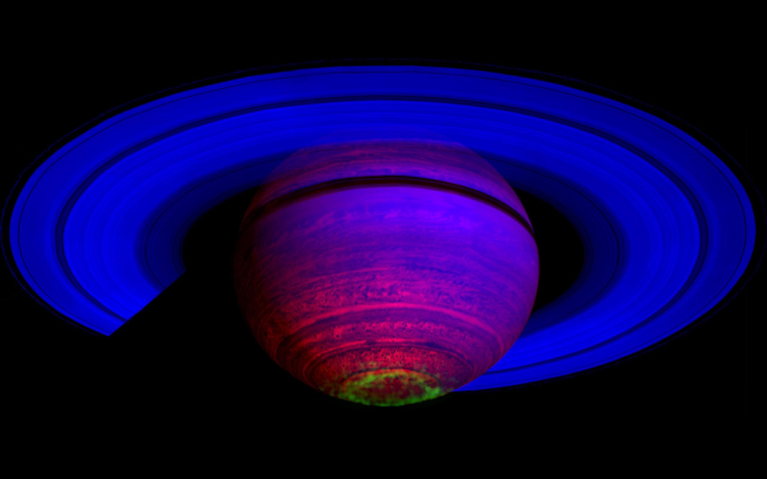 saturn in false color purple blue rings with green aurora circling south pole