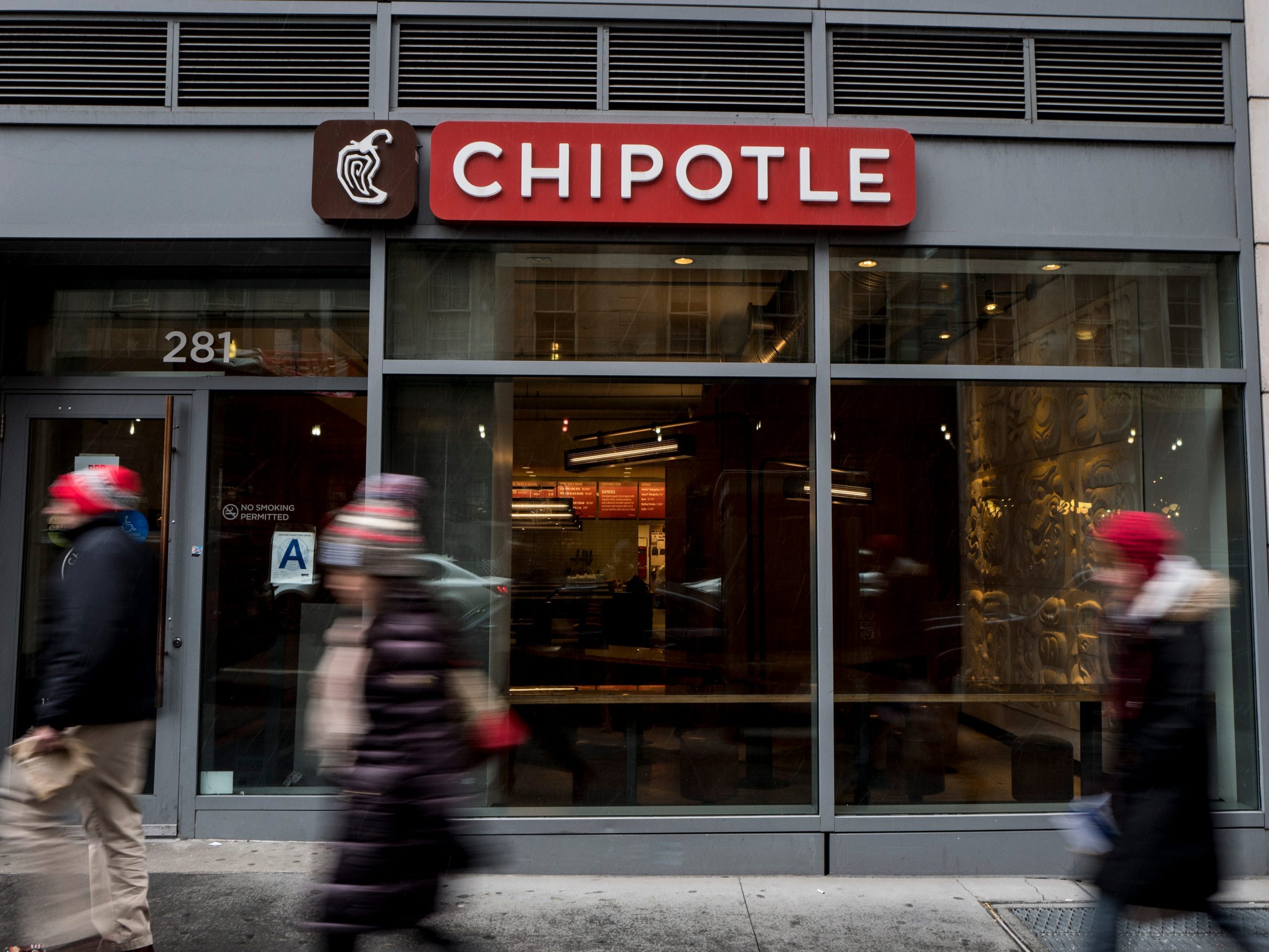 People walk past a Chipotle restaurant in NYC.