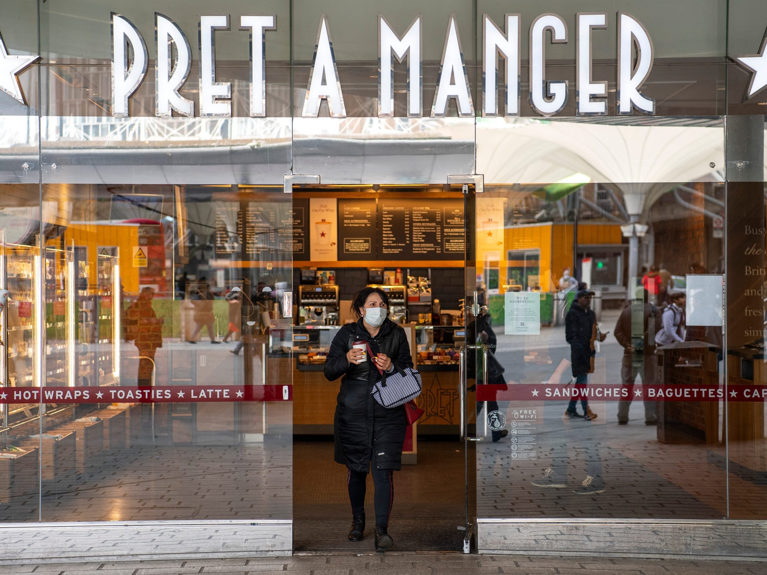 A woman in a protective face mask leaves a Pret A Manger restaurant on March 18, 2020 in London, England.
