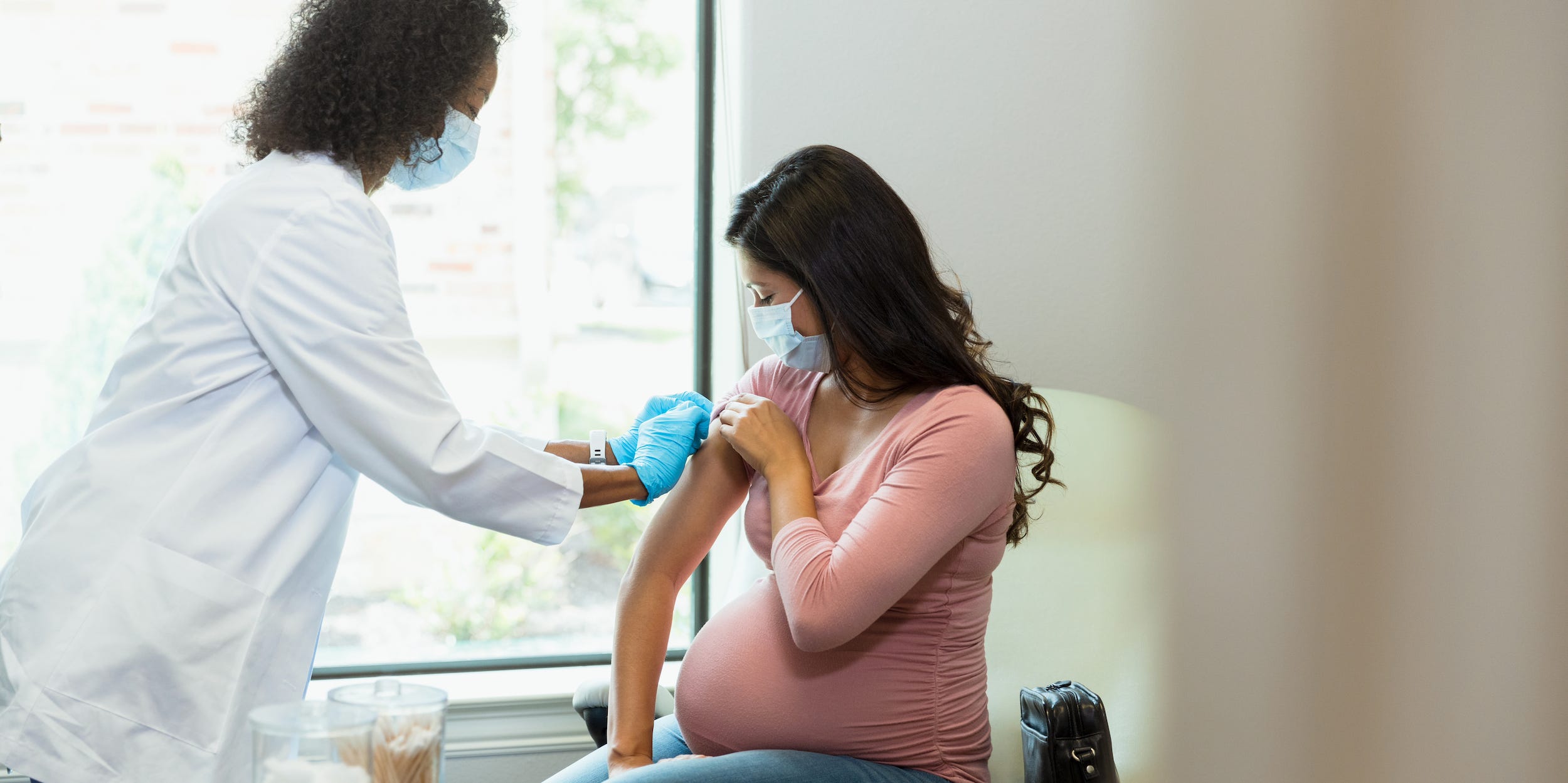 A pregnant woman receives a vaccine shot.