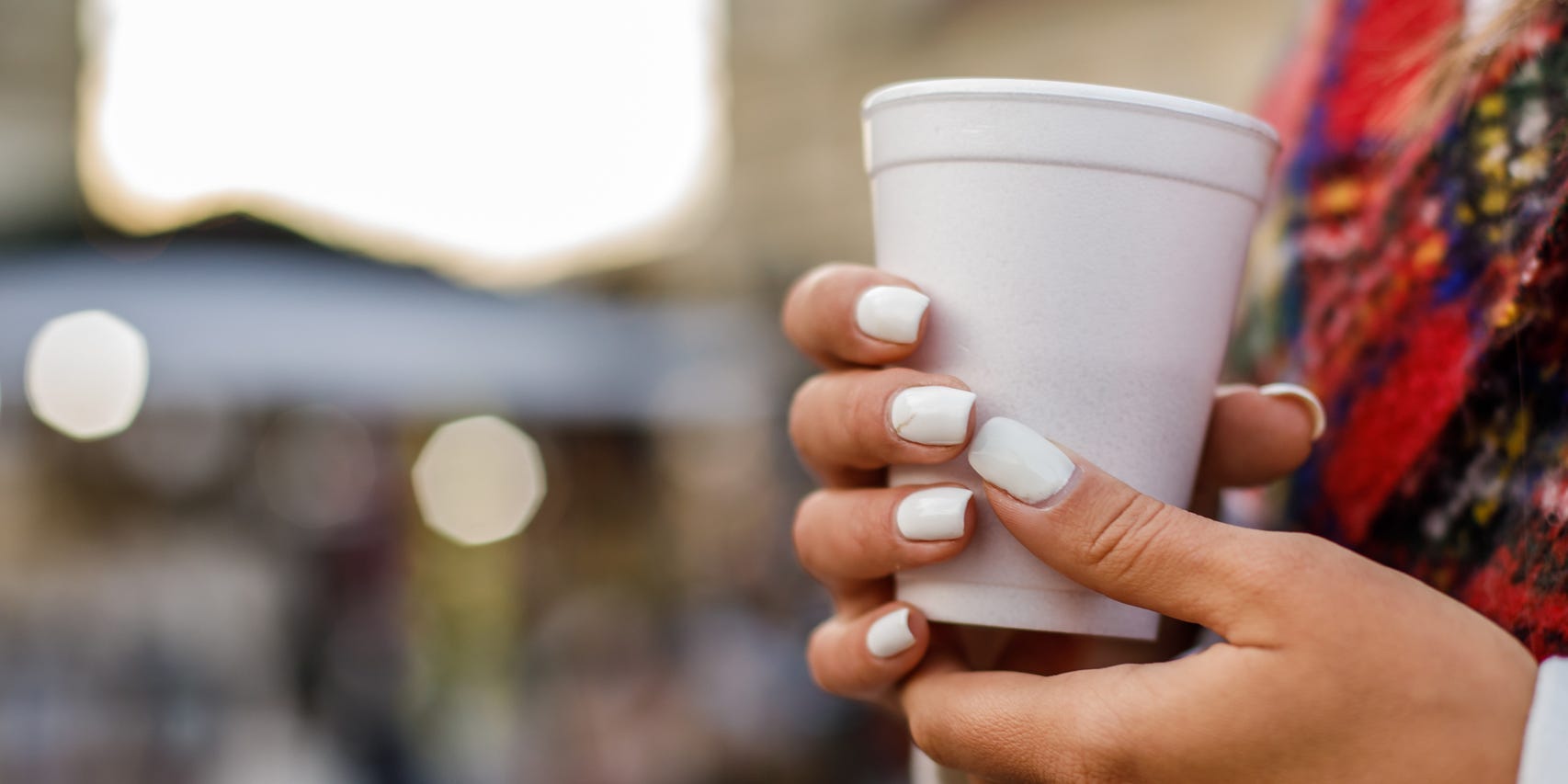 Close up of a person holding a styrofoam cup