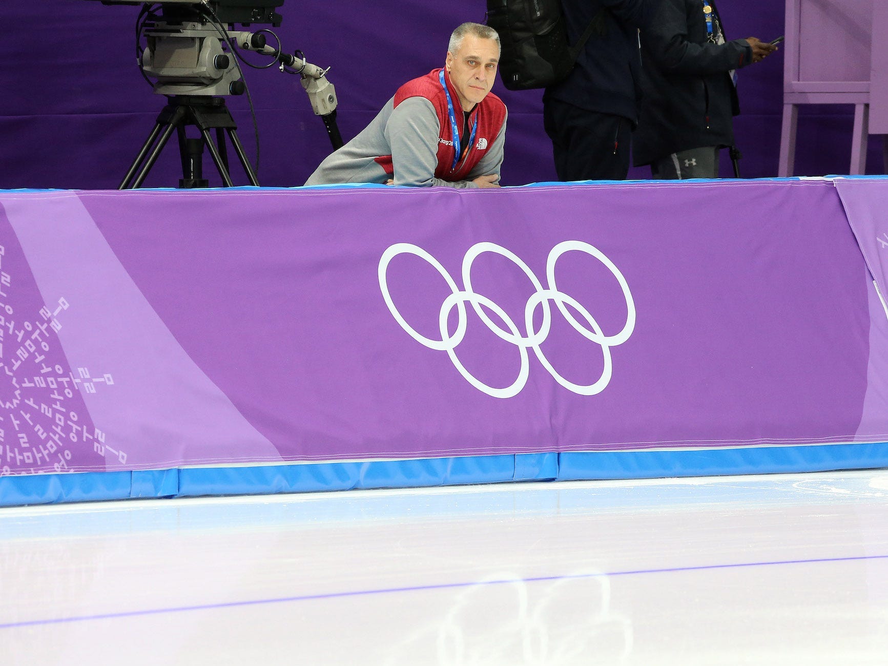 Mark Messer leans on a barrier and overlooks the ice oval at the 2018 Pyeongchang Olympics.