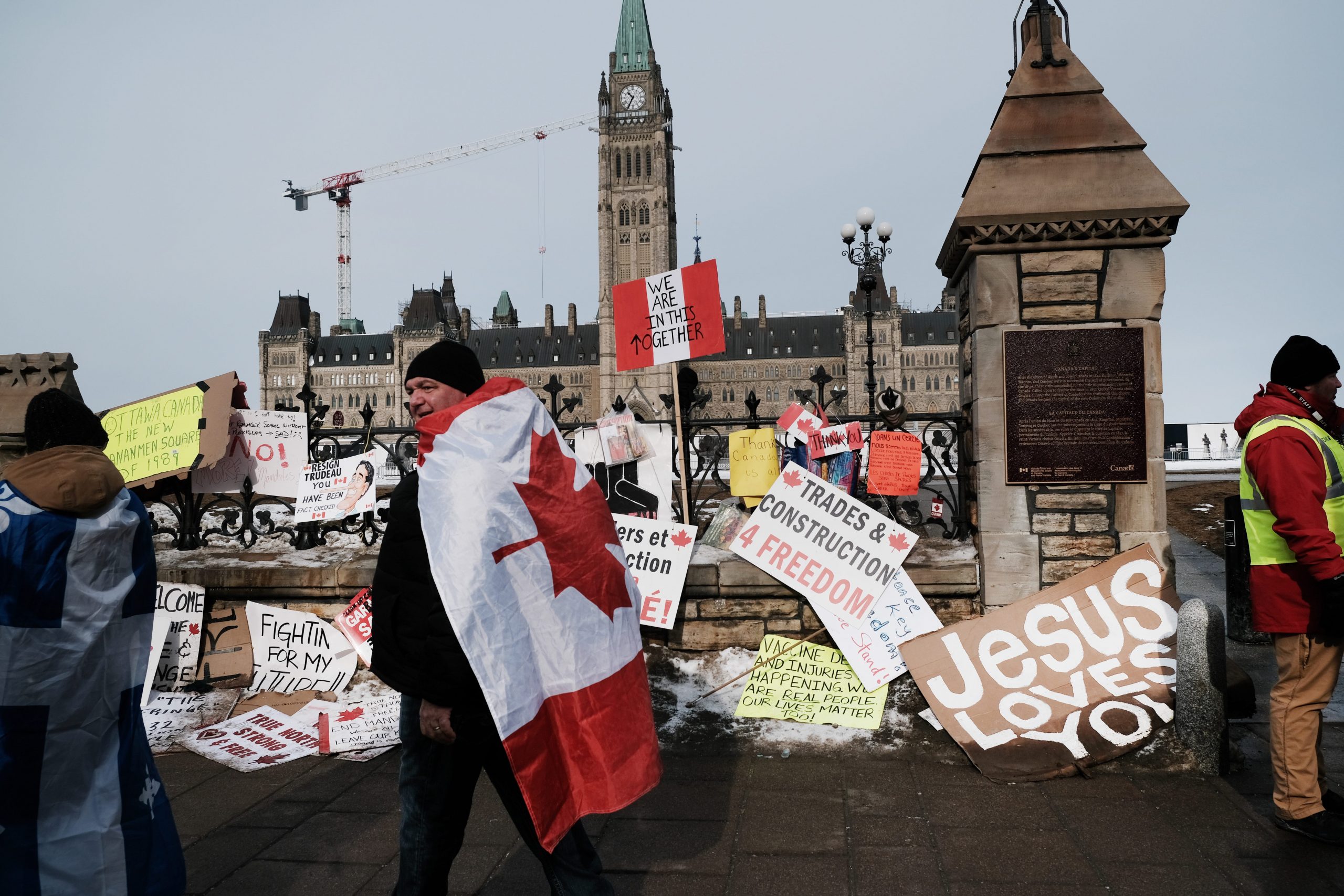 A man holds a sign as truck drivers and their supporters gather to block the streets as part of a convoy of truck protesters against COVID-19 mandates on February 09, 2022 in Ottawa, Ontario.