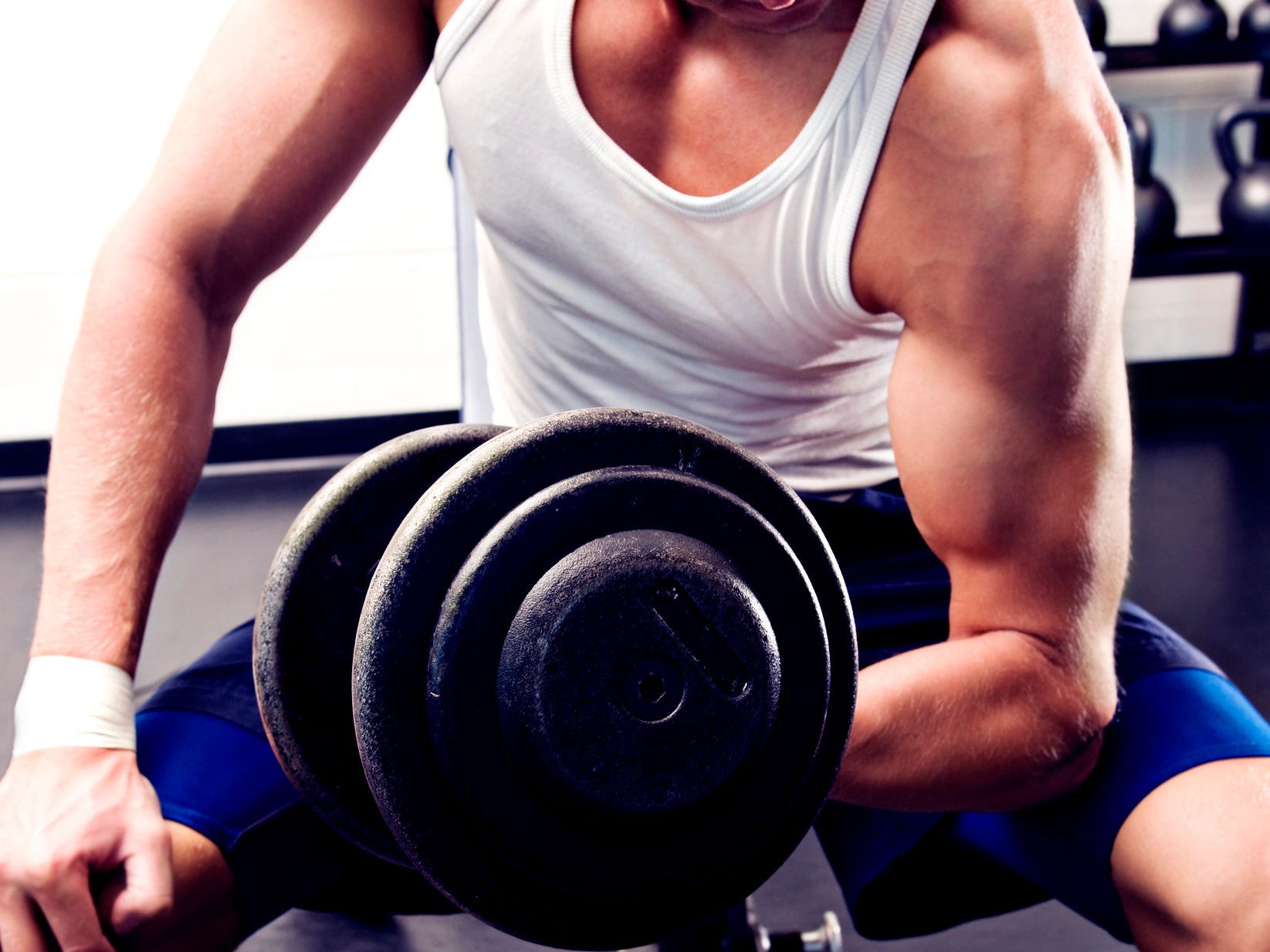 closeup view of a man bicep curling a dumbbell