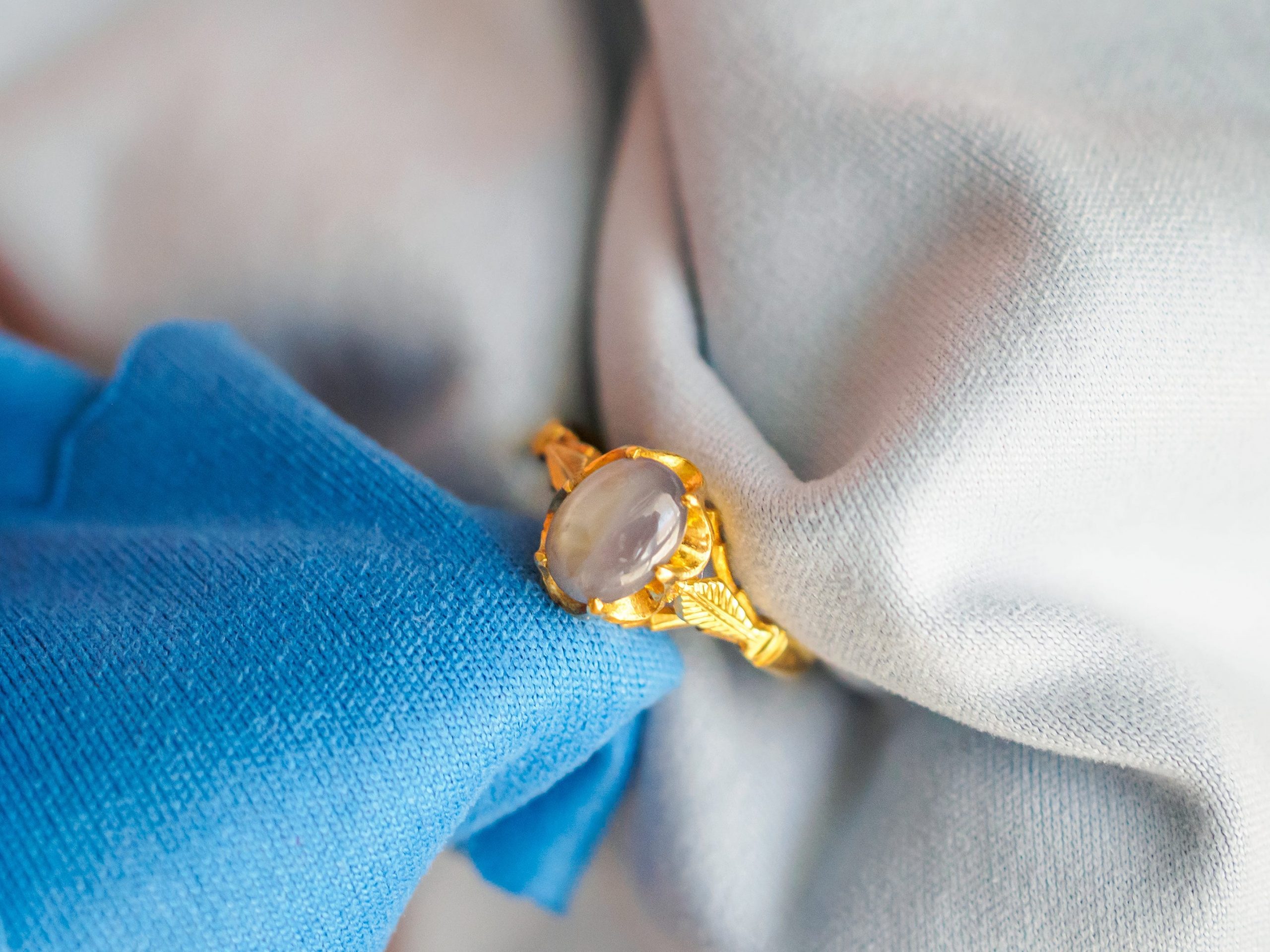 Gold ring being cleaned with microfiber towels