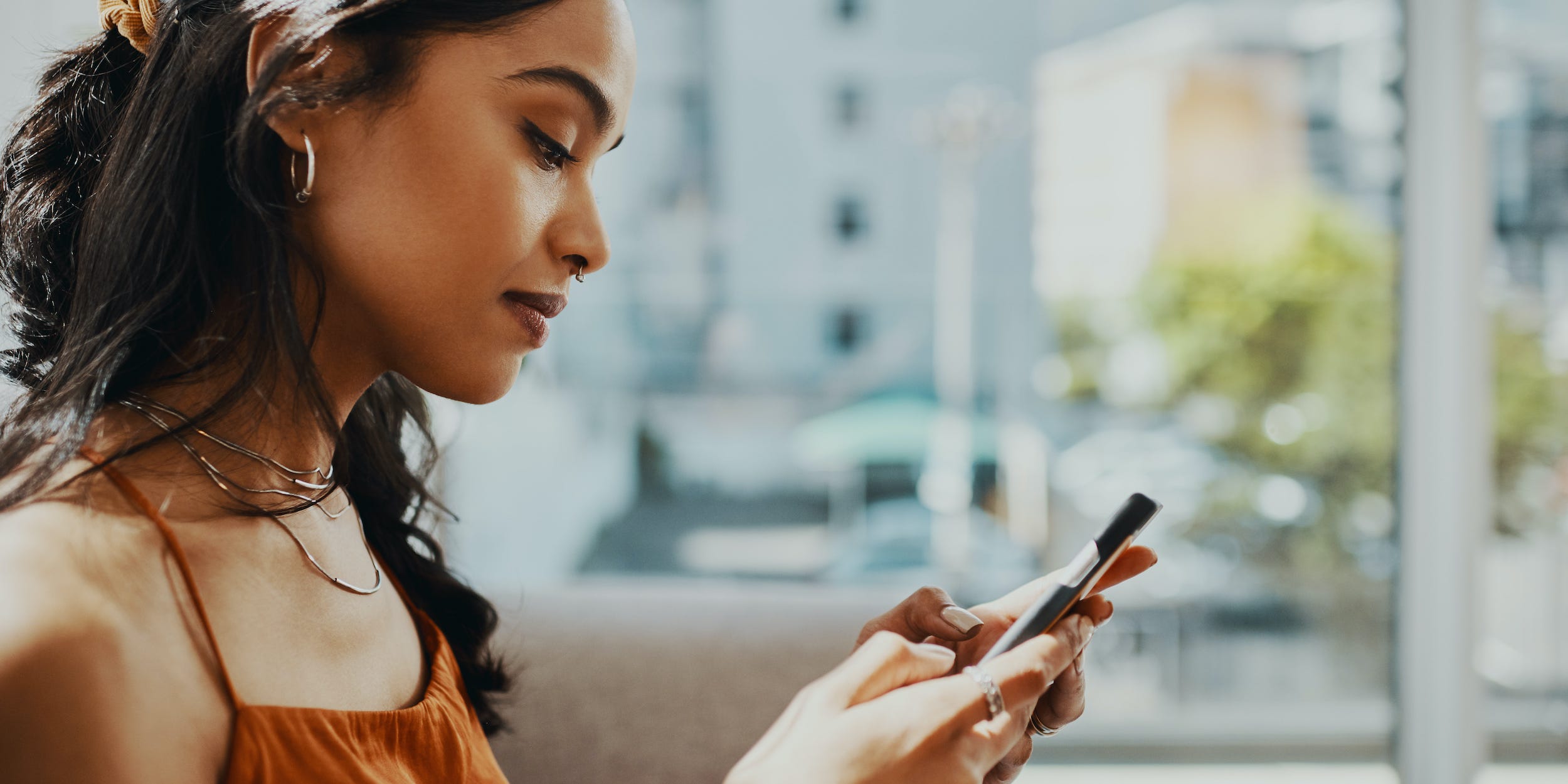 woman looking at phone texting at home