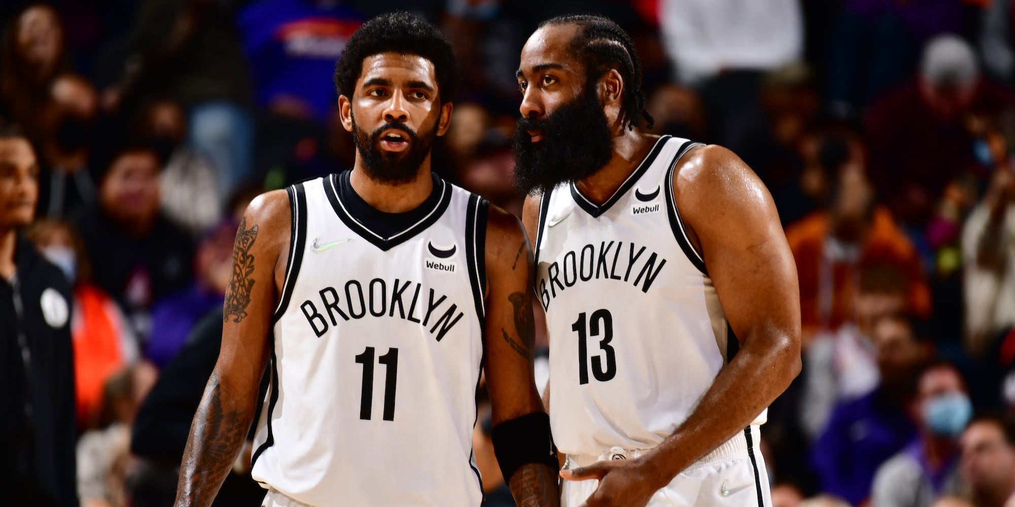 James Harden speaks to Kyrie Irving during a game in 2022.