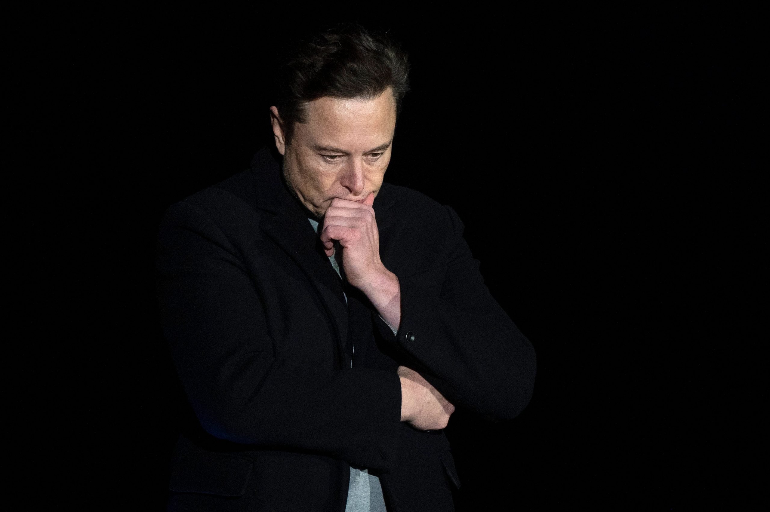 Elon Musk pauses and looks down as he speaks during a press conference at SpaceX's Starbase facility near Boca Chica Village in South Texas on February 10, 2022