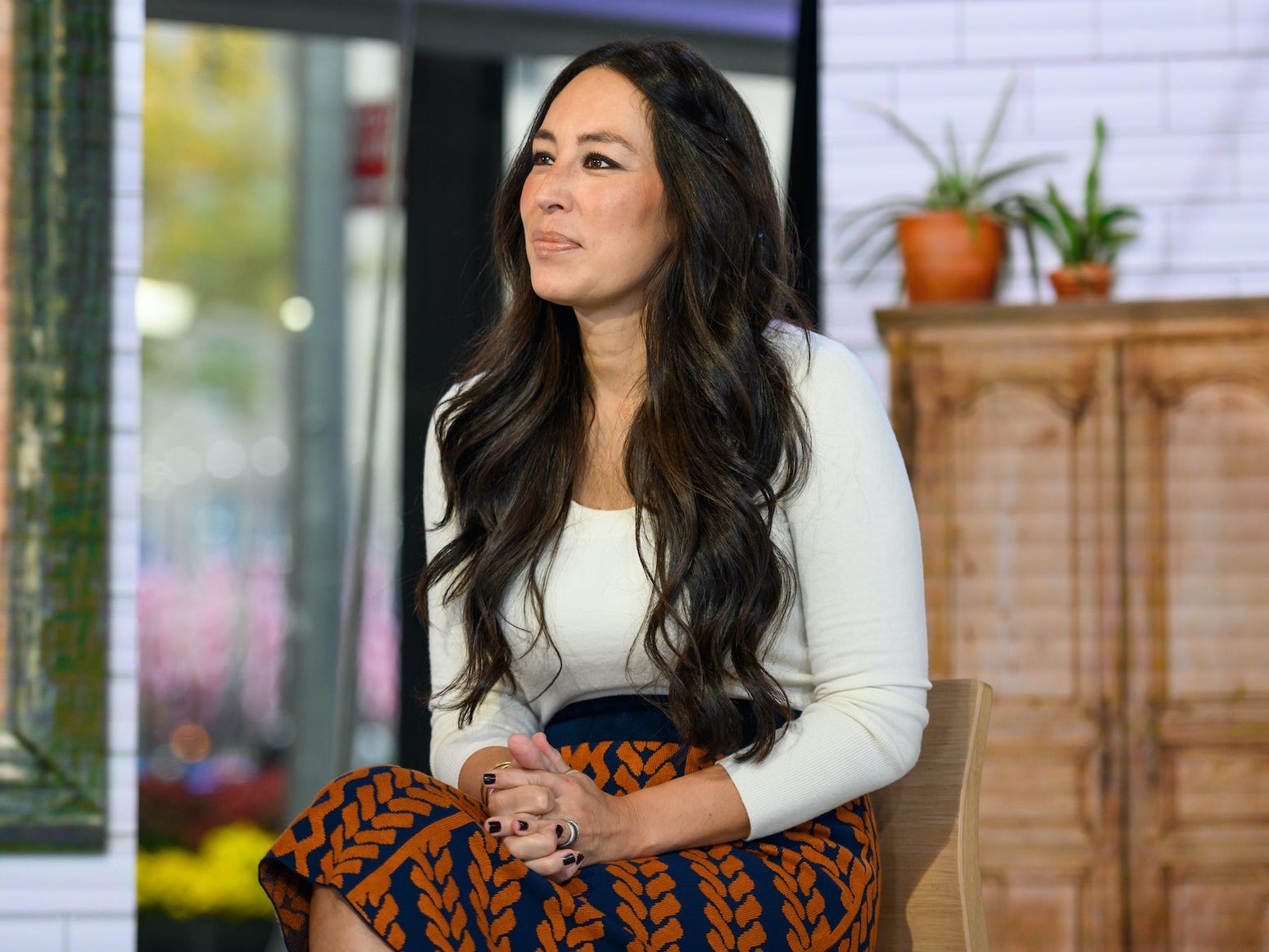 Joanna Gaines sits with her hands in her lap.