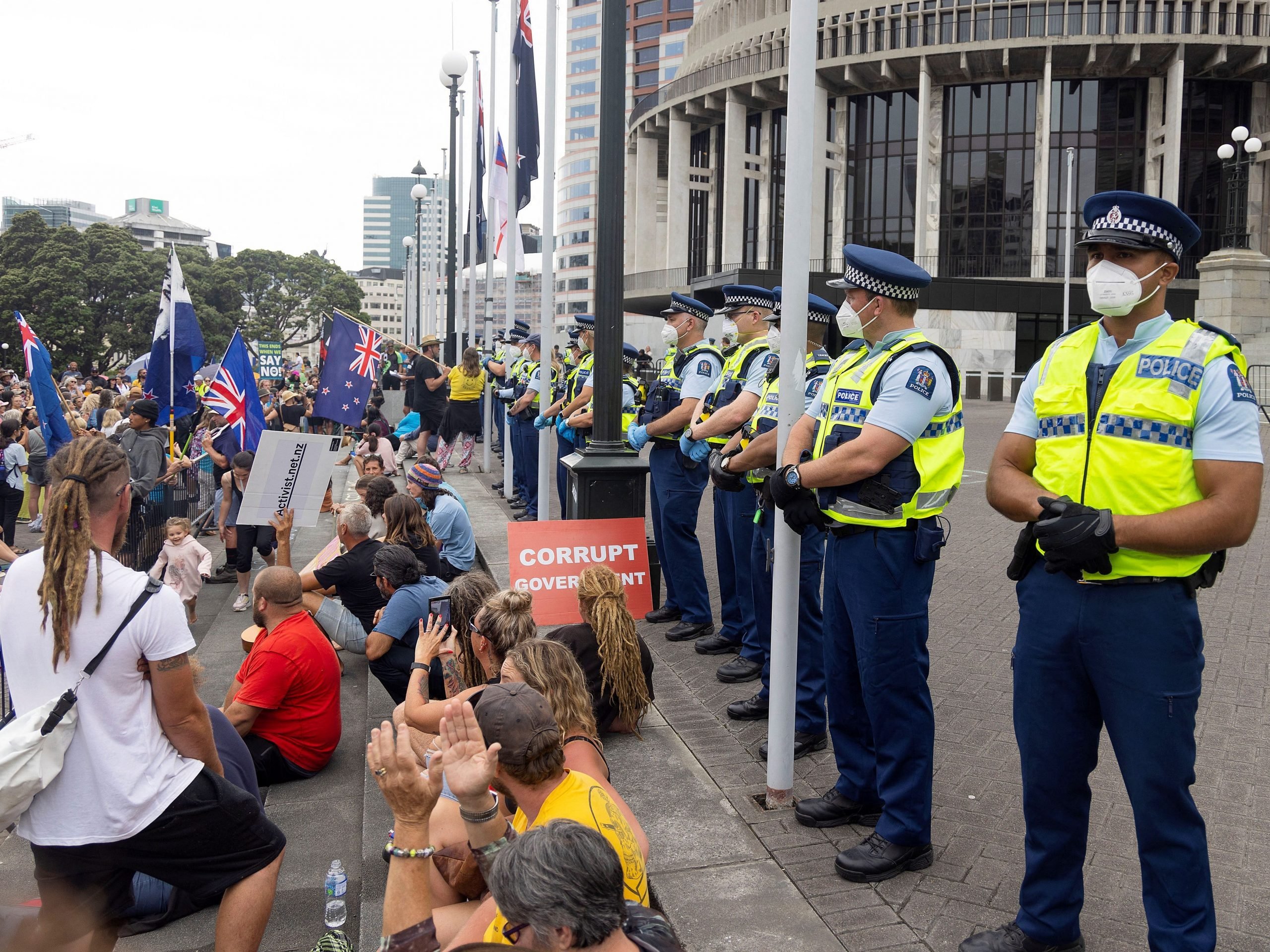 Police (R) watch as protesters occupy the grounds around the parliament building in Wellington on February 9, 2022, on the second day of demonstrations against Covid restrictions, inspired by a similar demonstration in Canada