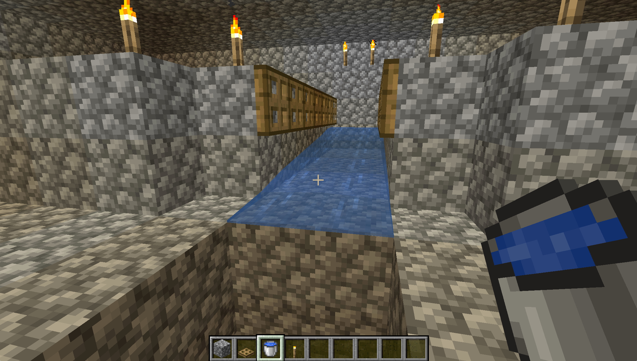 A screenshot from Minecraft, showing water flowing down a bridge.