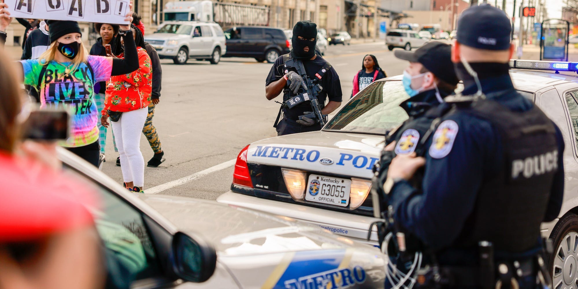 A protester holding a placard expressing her opinion in front of police during a memorial march from Jefferson Square Park to mark the one year anniversary since the Louisville Metro Police Department shot and killed Breonna Taylor at her home in Louisville.