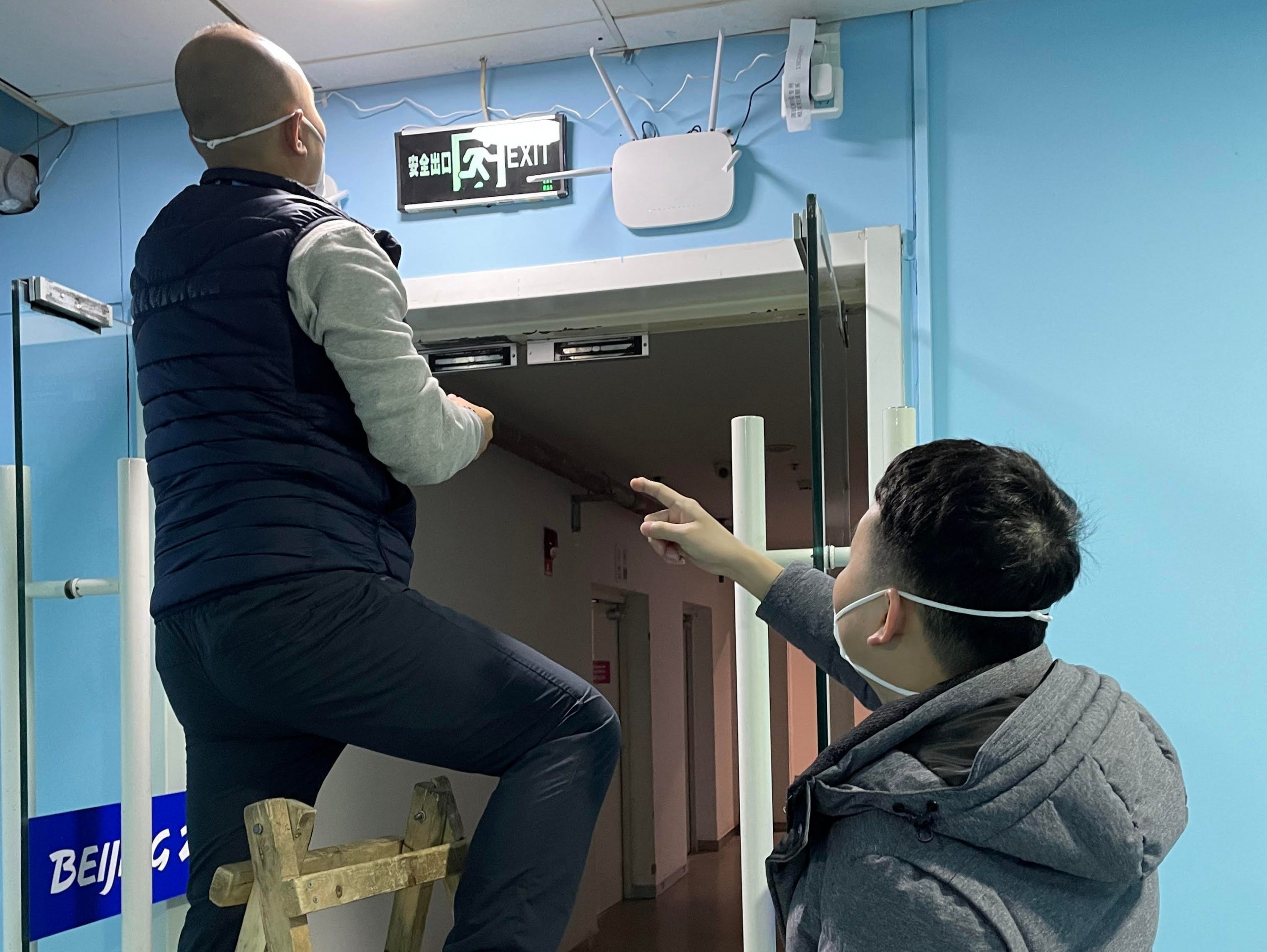 Refresh Inc. employees setting up base stations and transmitters at the Beijing National Aquatic Center to receive and send data from the thermometers.