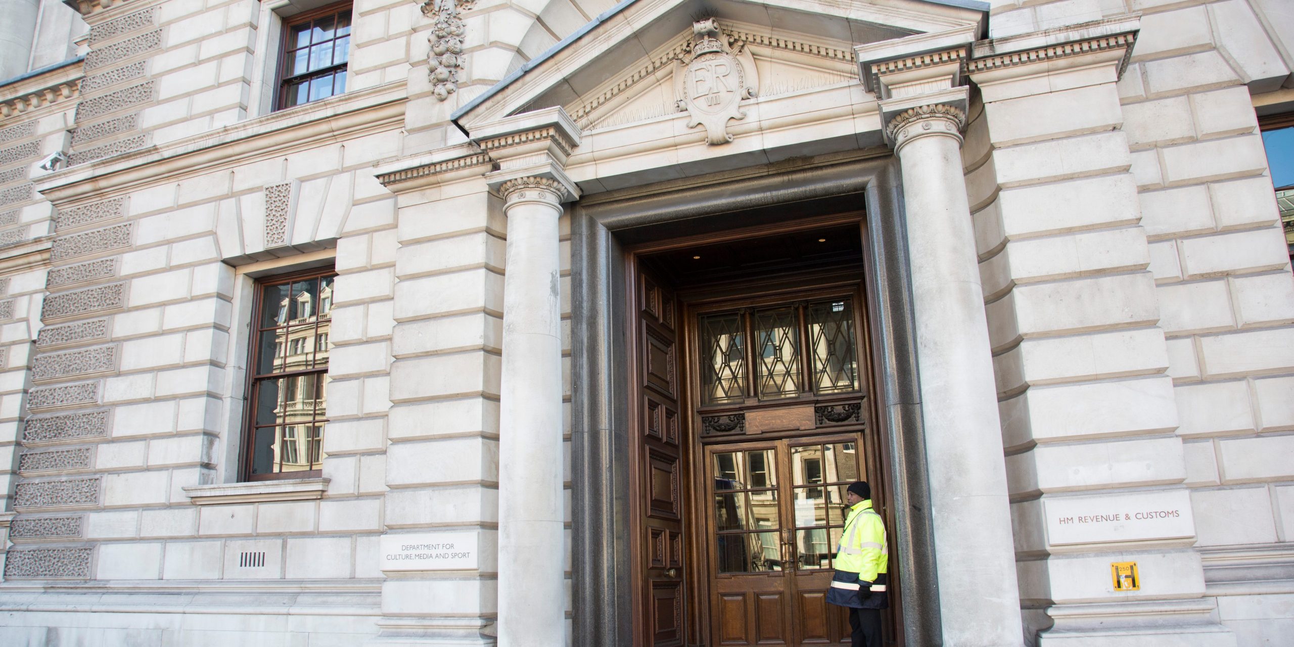 A guard stands at the HM Revenue and Customs building in London.