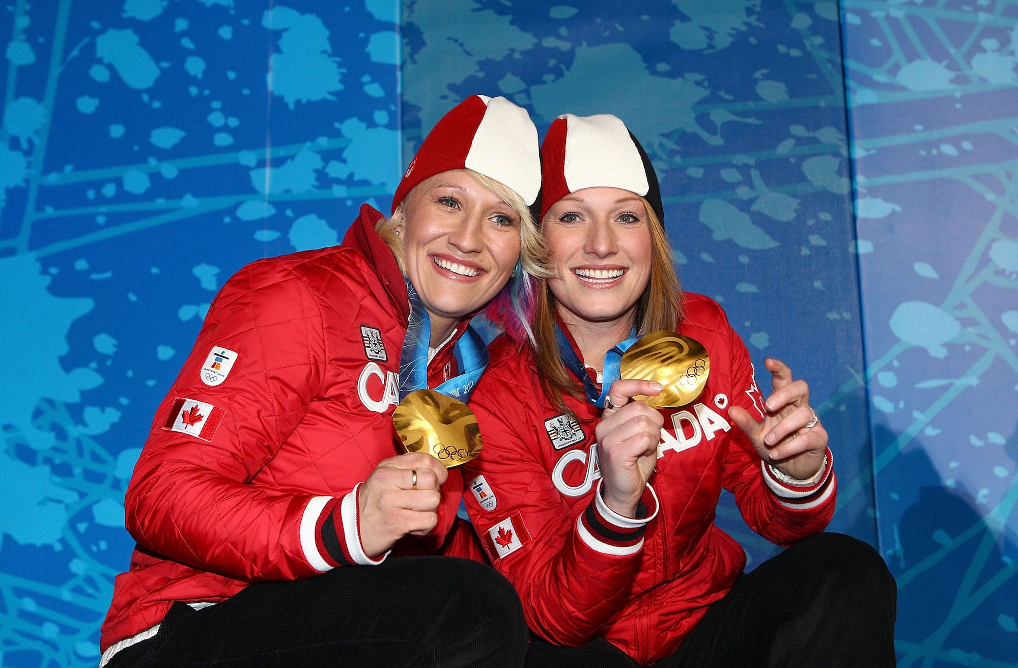 Kaillie Humphries (L) and Heather Moyse of Canada celebrate receiving the gold medal during the medal ceremony for the women's two-man bobsleigh held at the Whistler Medals Plaza ceremony on day 14 of the Vancouver 2010 Winter Olympics at Whistler Medals Plaza