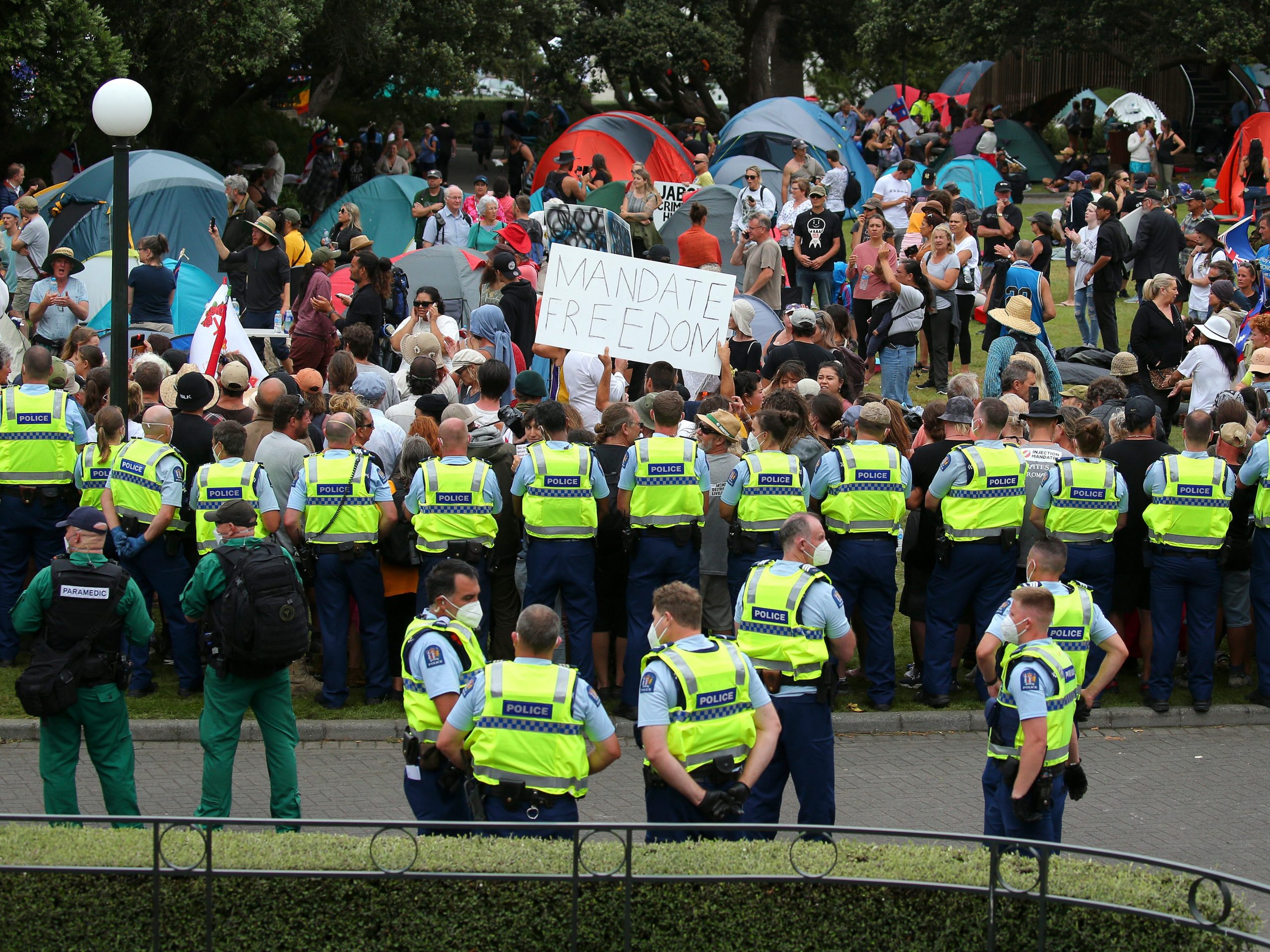 Police officers form a line in front of protesters at Parliament on February 10, 2022 in Wellington, New Zealand