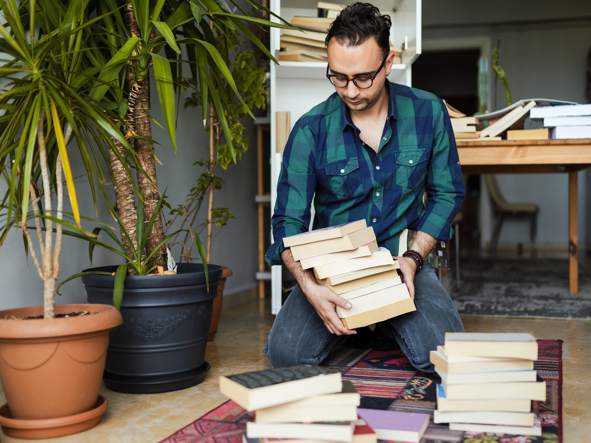 Person kneeling on the floor organizing some books