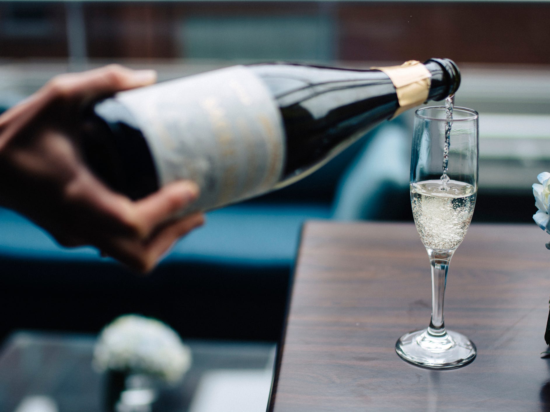 Close-up of someone pouring Champagne into a glass.