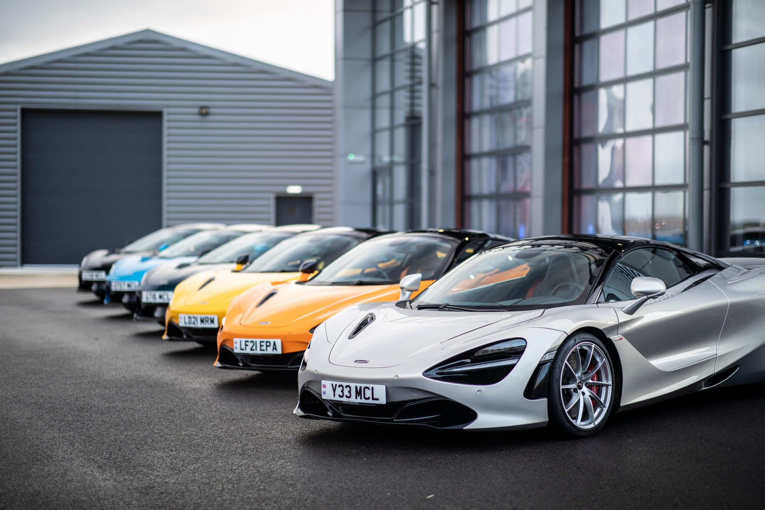 A row of parked McLarens, led by a silver 720S.