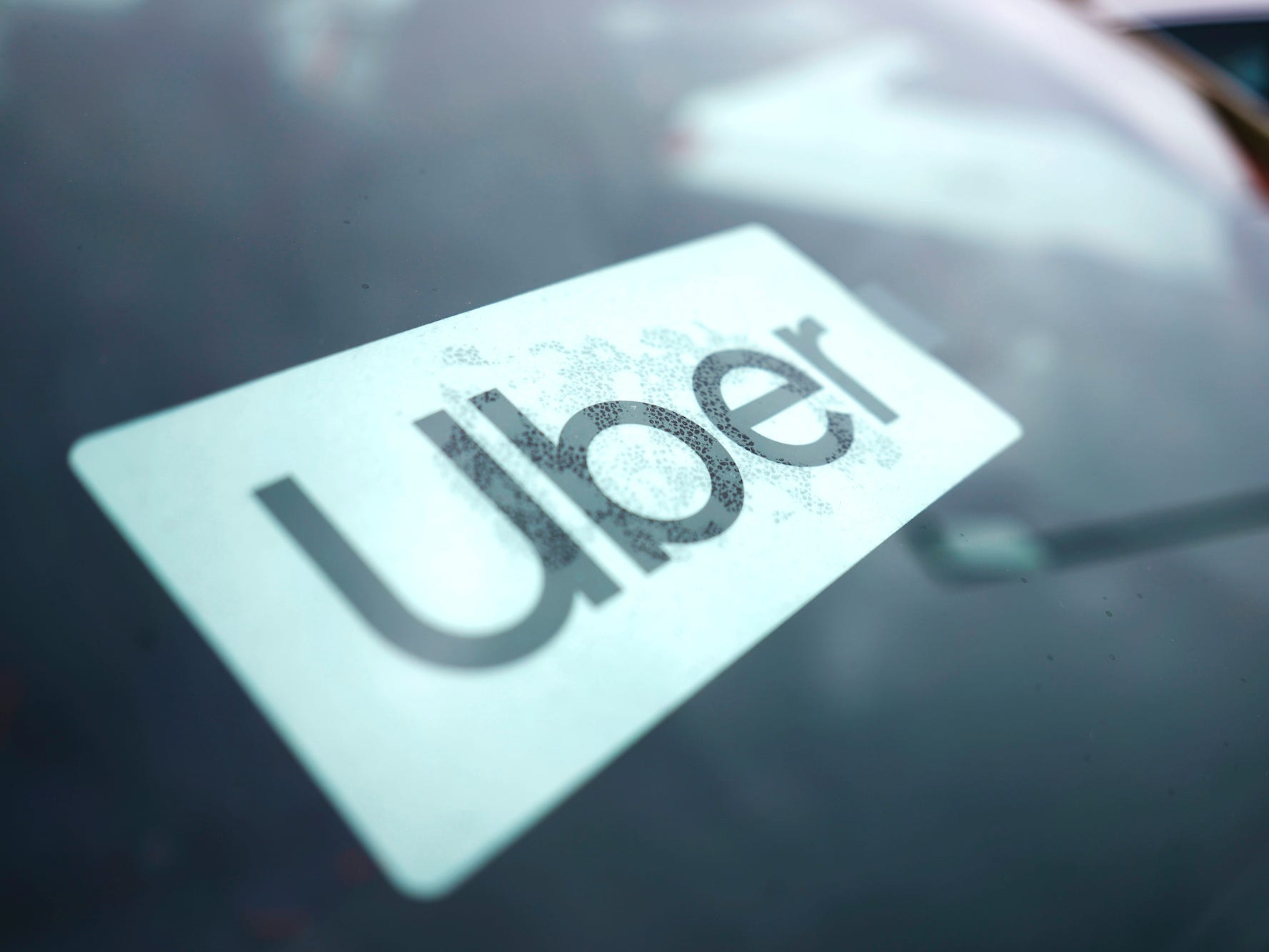 An Uber sign is displayed inside a car in Palatine, Ill.,