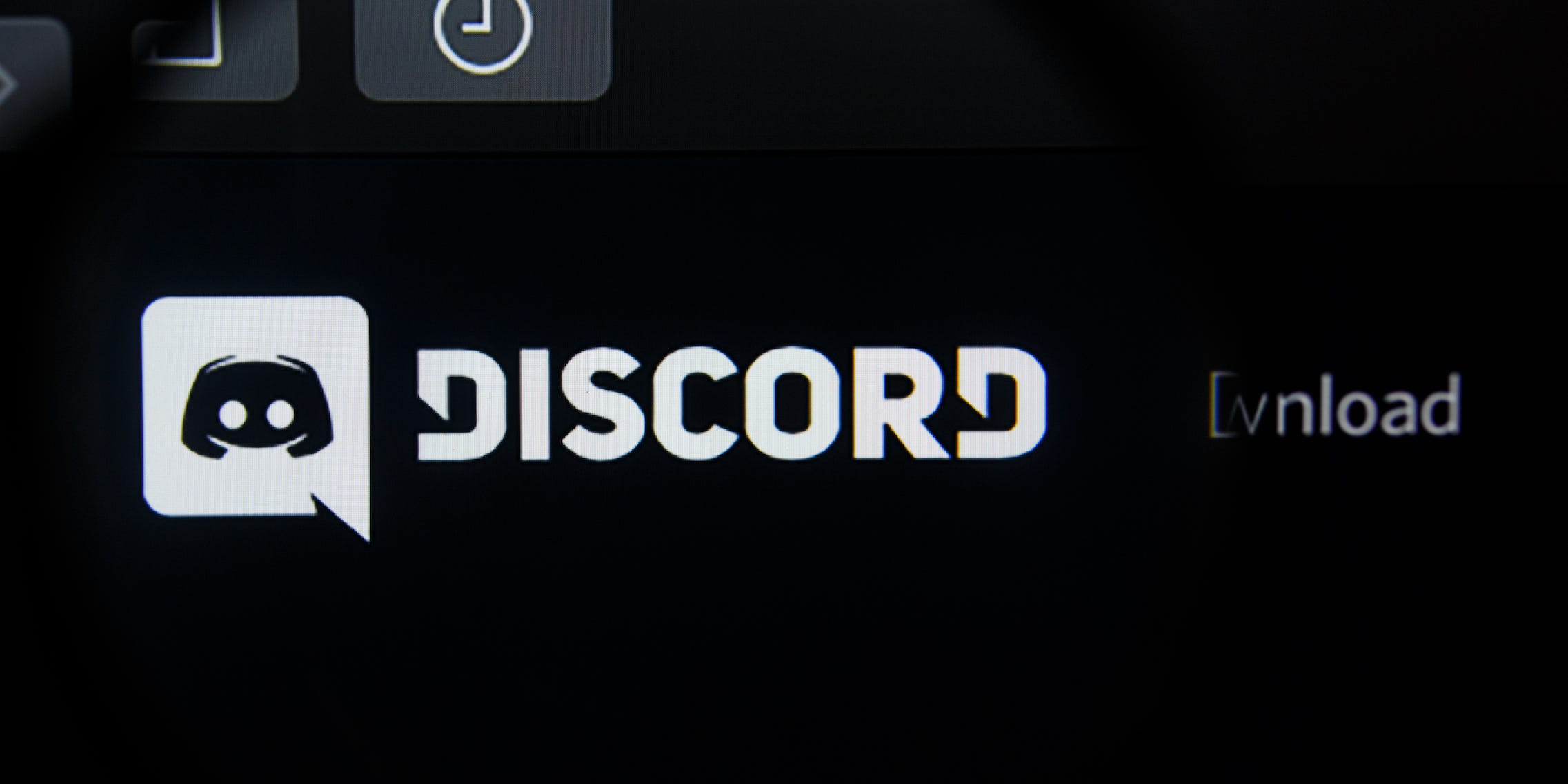 The Discord logo, seen through a magnifying glass.