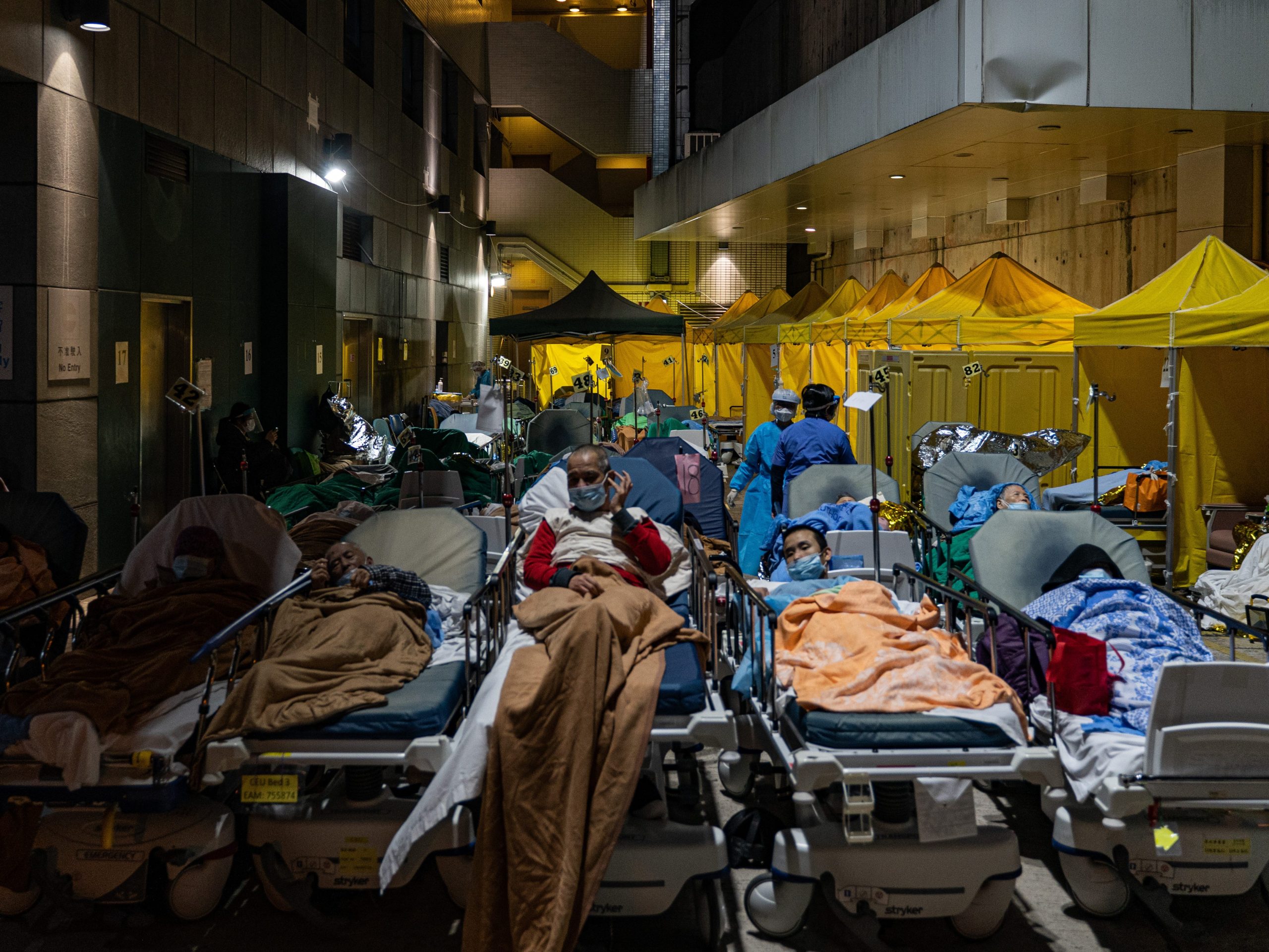 On February 16, 2022, in a temporary shelter outside Caritas Medical Center in Hong Kong, China, a patient lies in a hospital bed waiting for medical treatment.