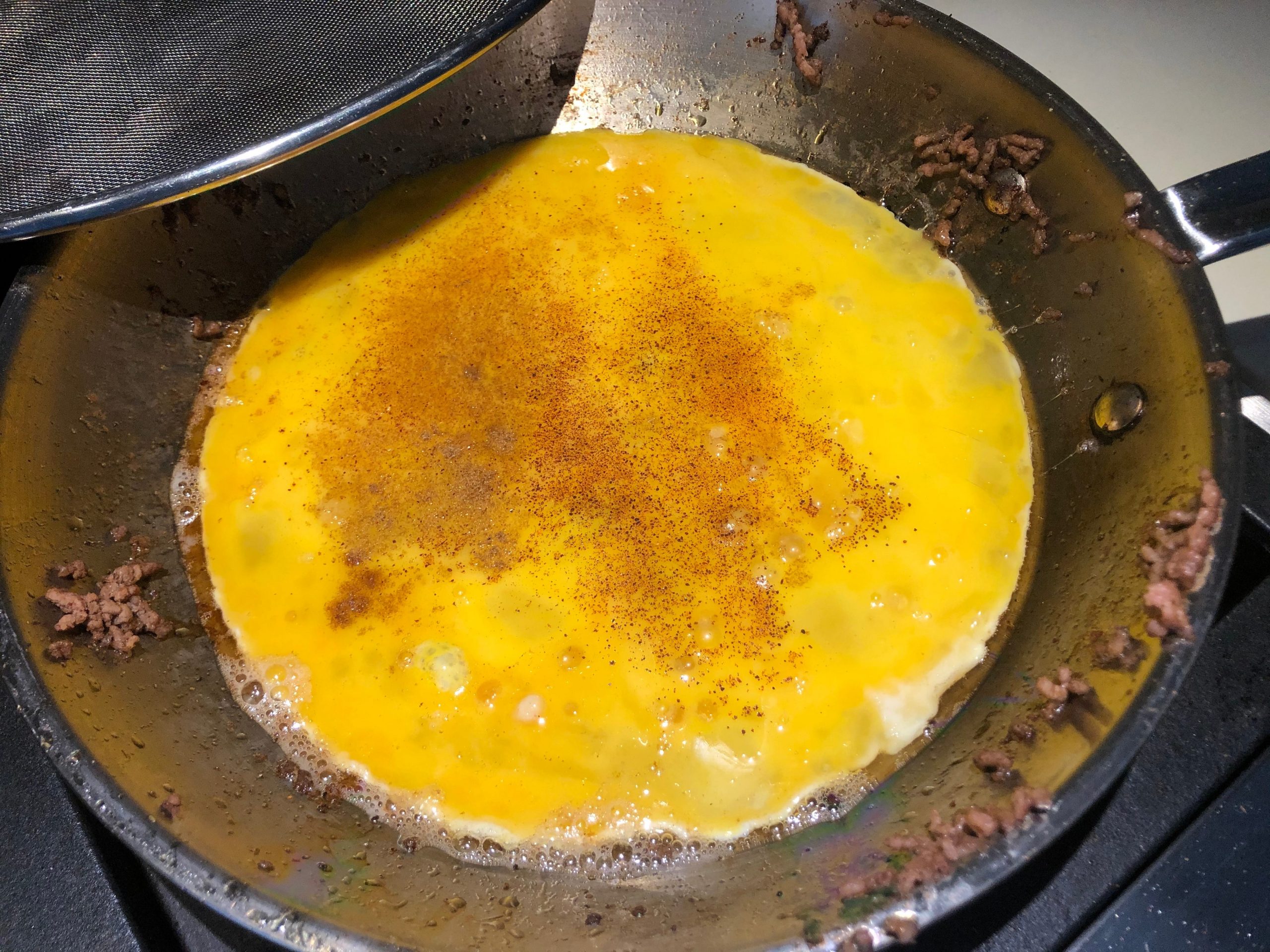 Eggs being scrambled in pan with spices