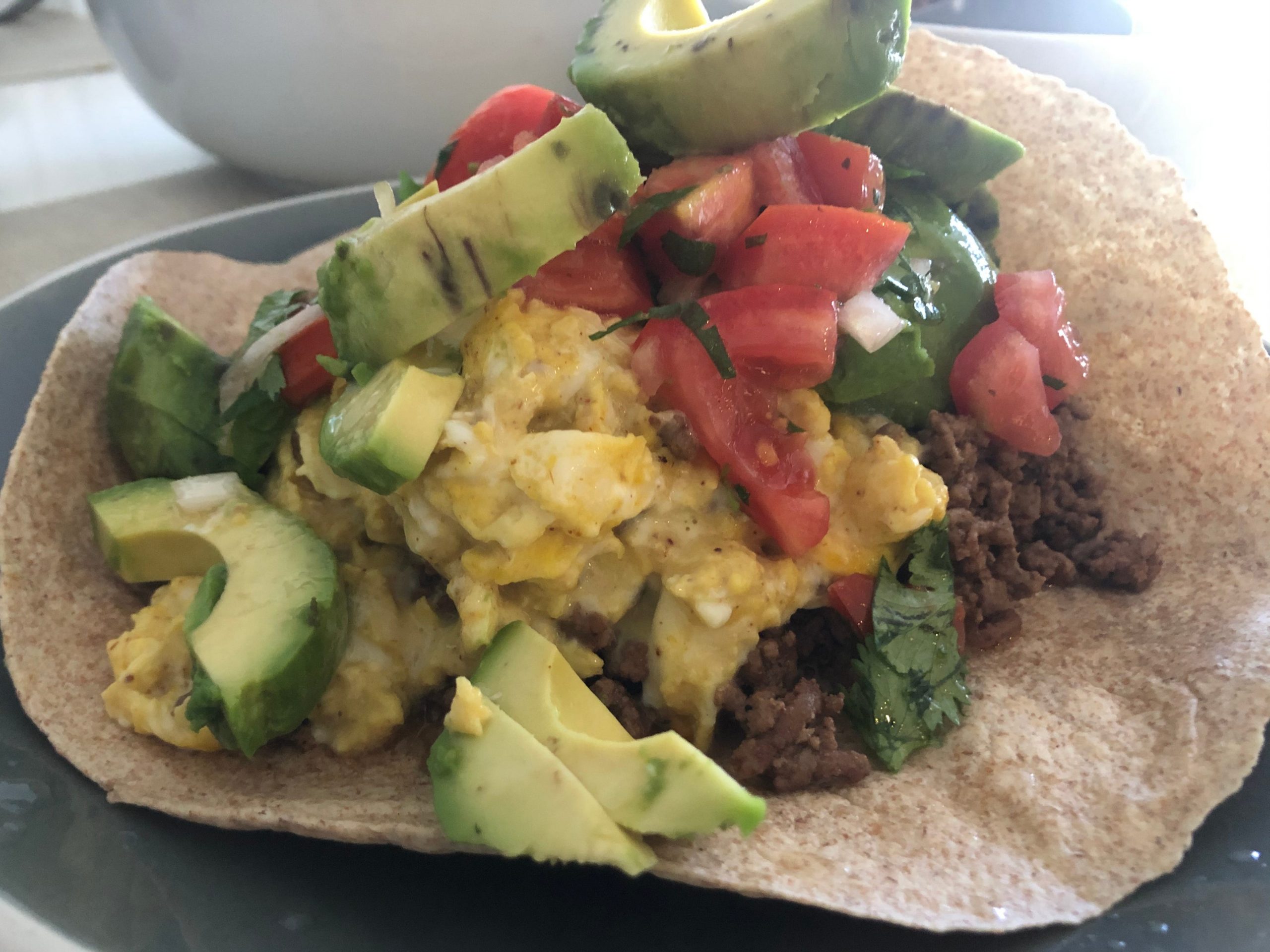 unfolded Tortilla loaded with ingredients like eggs and meat