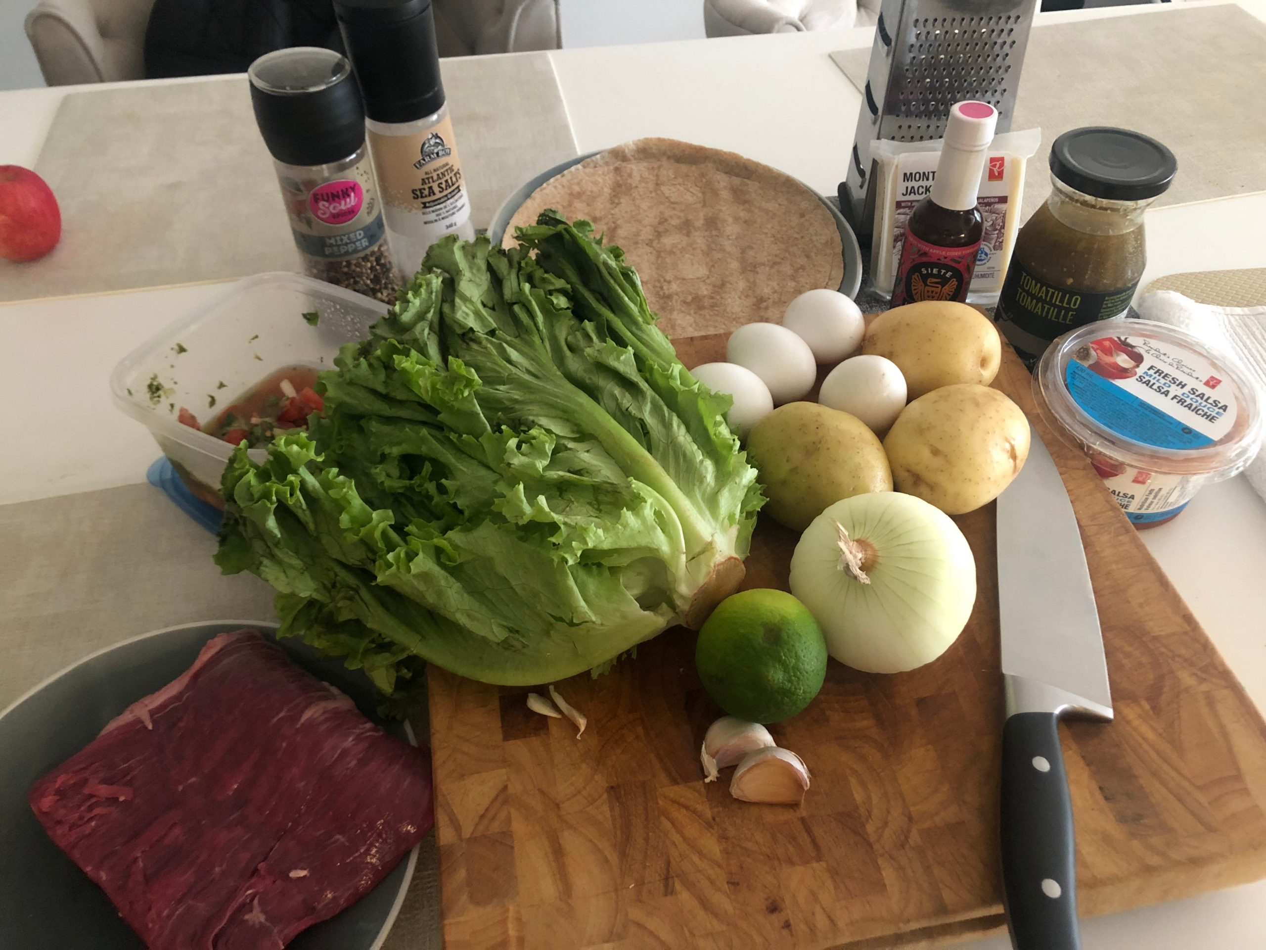 The ingredients for Guy Fieri's breakfast burrito laid out on wooden cutting board