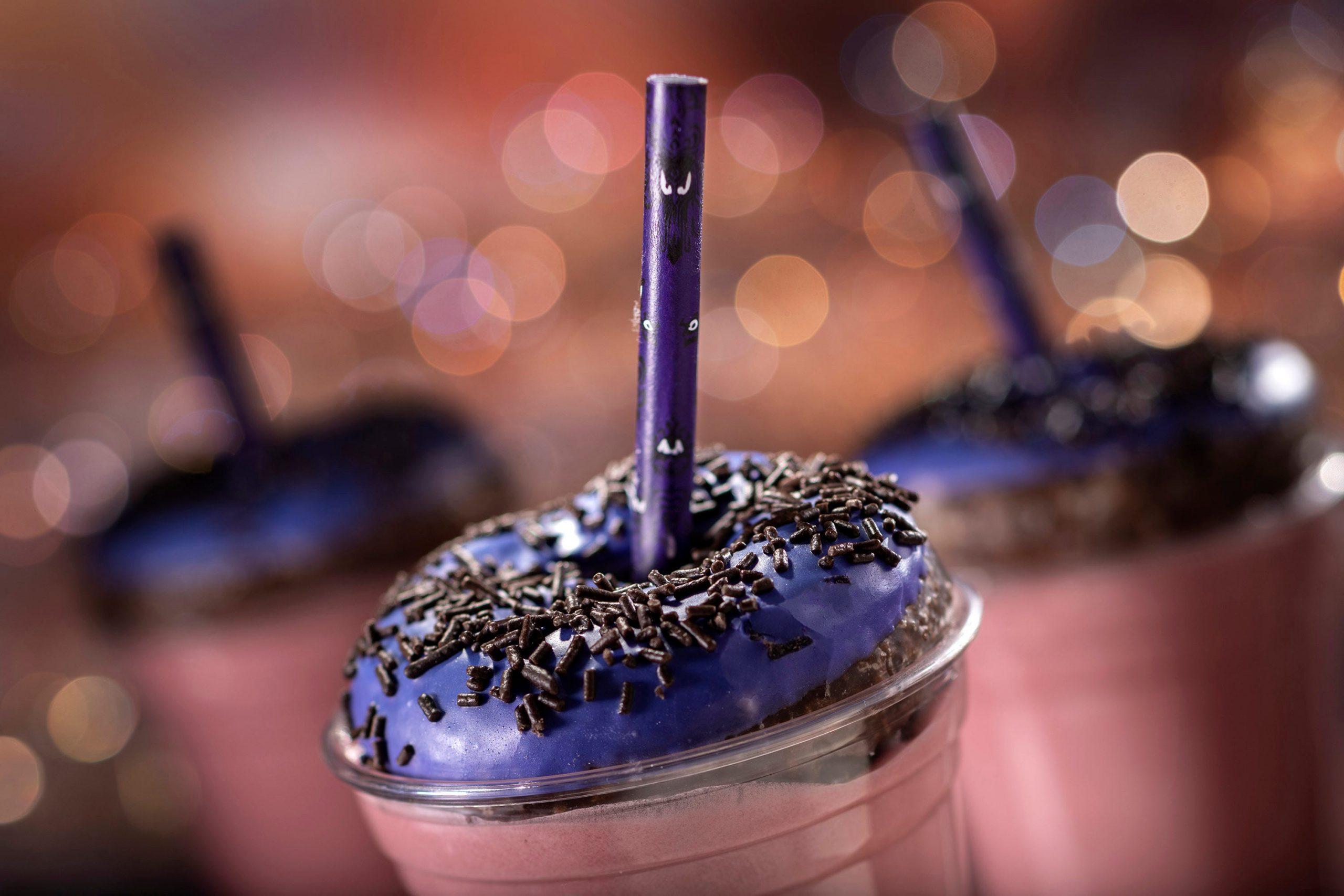 One of Disney's culinary creations, which is a purple shake with a purple sprinkled donut on top.