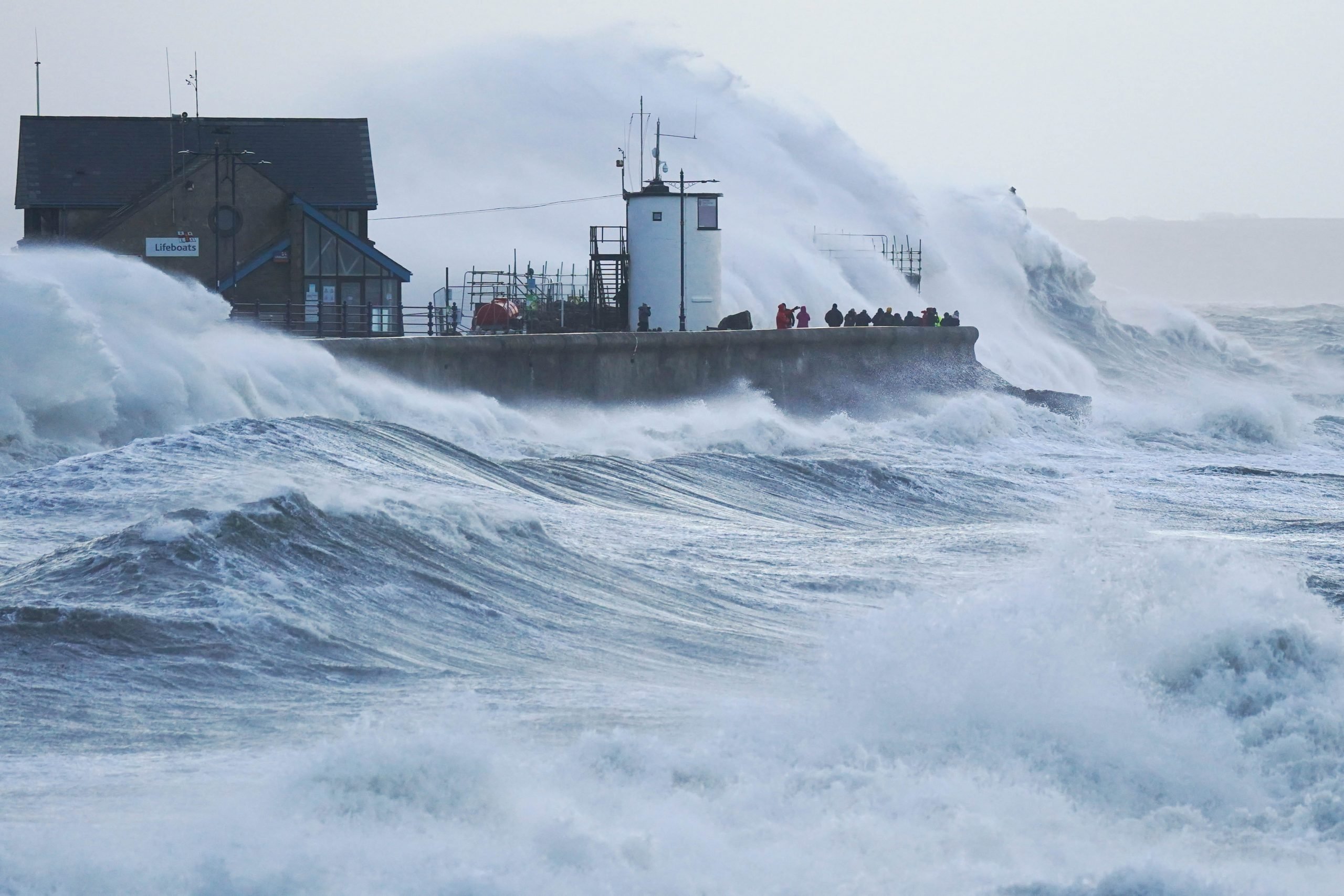 Waves crash against the sea wall and Porthcawl Lighthouse in Porthcawl, Bridgend, Wales, as Storm Eunice hits the south coast