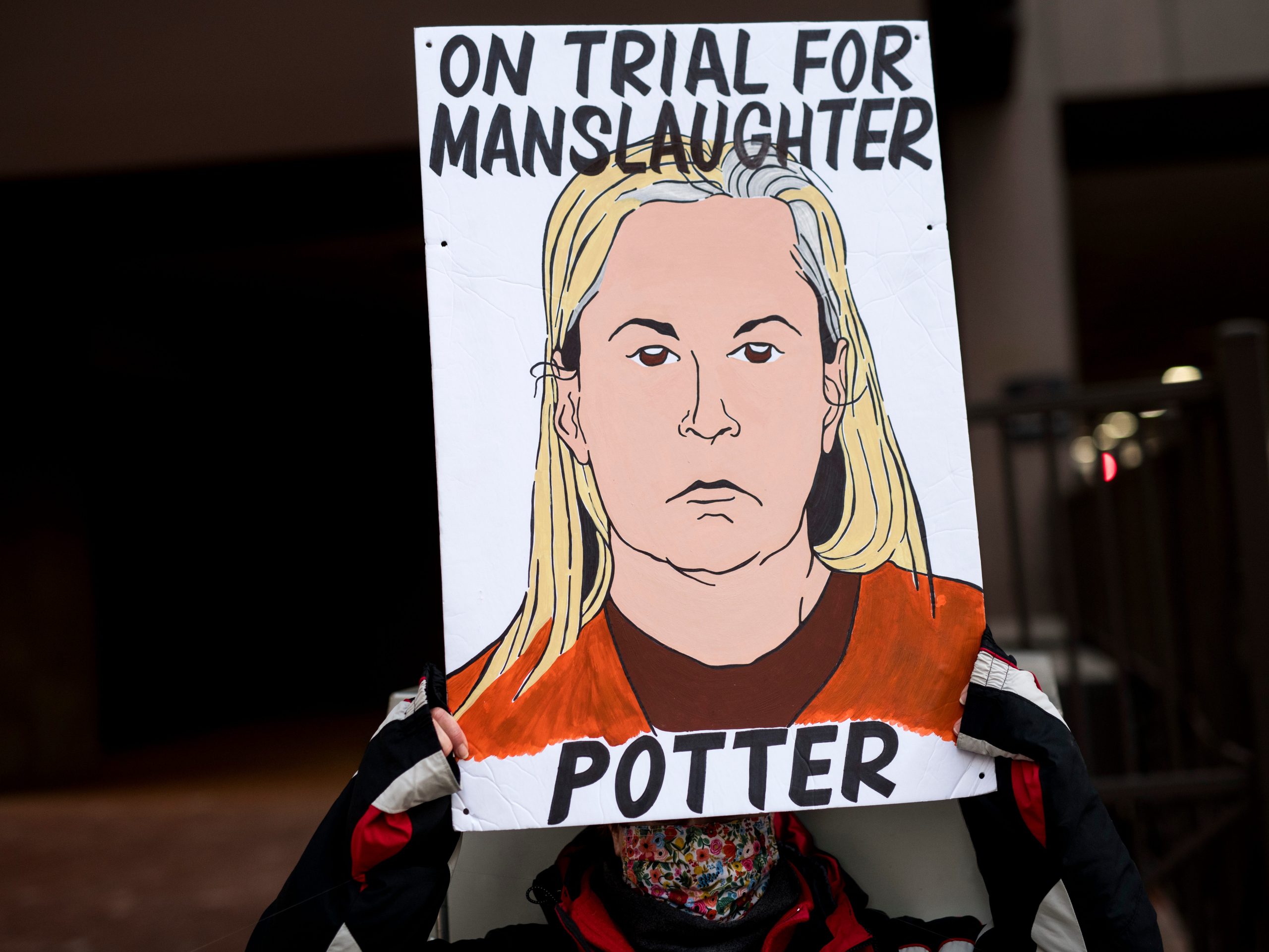 A person holds a sign as they demonstrate outside the Hennepin County Government Center on December 23, 2021 in Minneapolis, Minnesota.