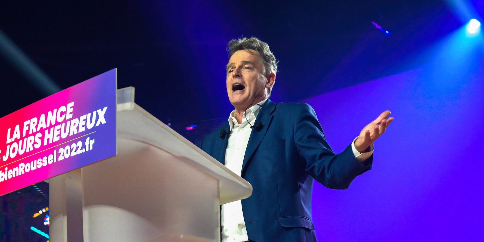 Fabien Roussel gestures upwards in a speech from behind a podium.