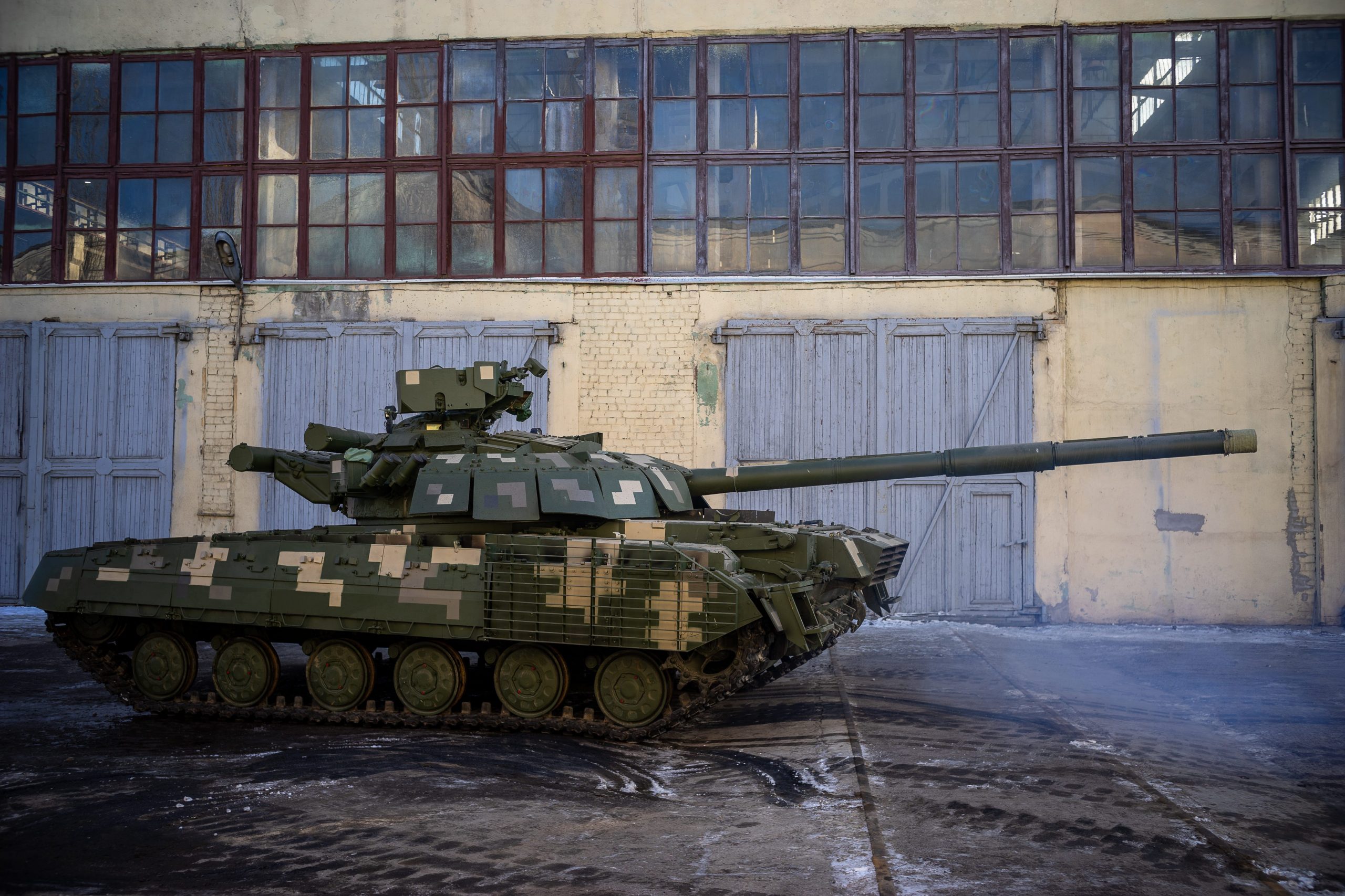 A tank is seen next to a building.