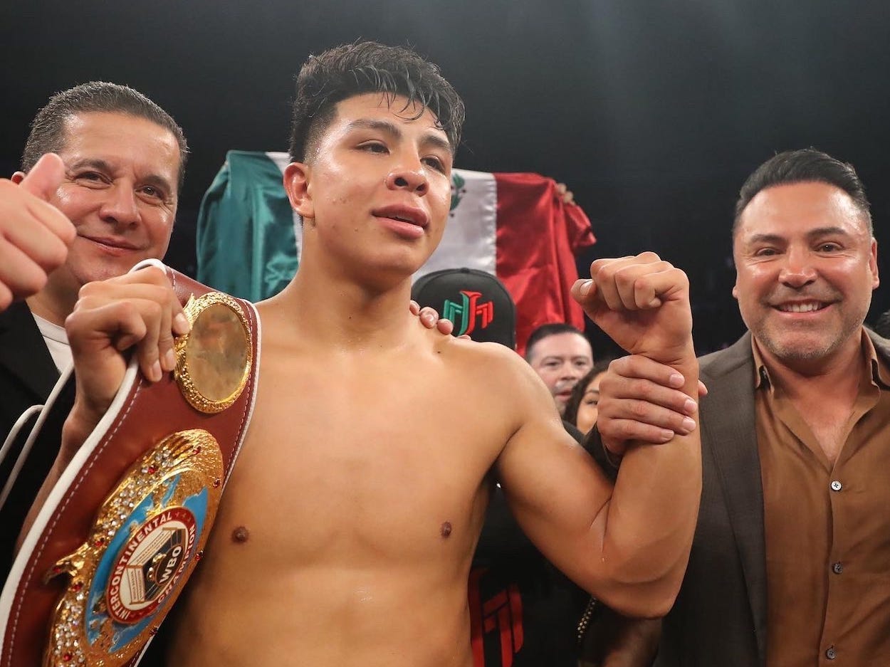 Jaime Munguia celebrates his win alongside promoter Oscar de la Hoya.